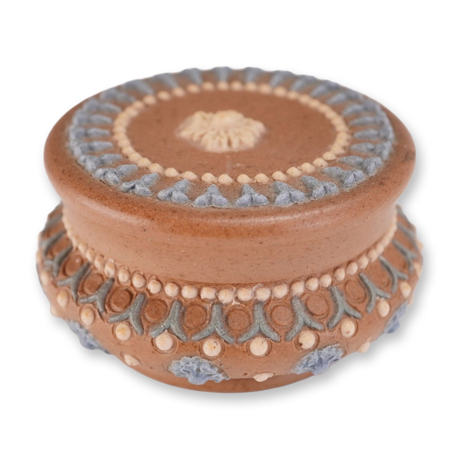 Doulton Lambeth Harriet Hibbut Stoneware Lidded Box: The exterior features applied sprigged ornamentation in shades of light blue, gray-blue, and cream. The flat-topped lid is centered with a cream-colored floral rosette encircled by beaded dots and sty