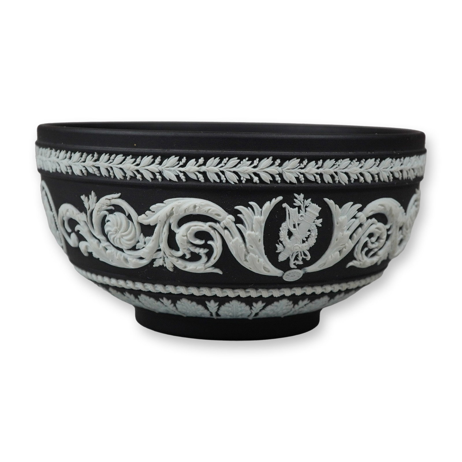 Wedgwood Black Jasperware Arabesque Bowl: A circular footed bowl crafted from black basalt-style stoneware. The exterior features a matte black finish decorated with intricate applied white relief (sprigged) ornamentation in the Neoclassical 