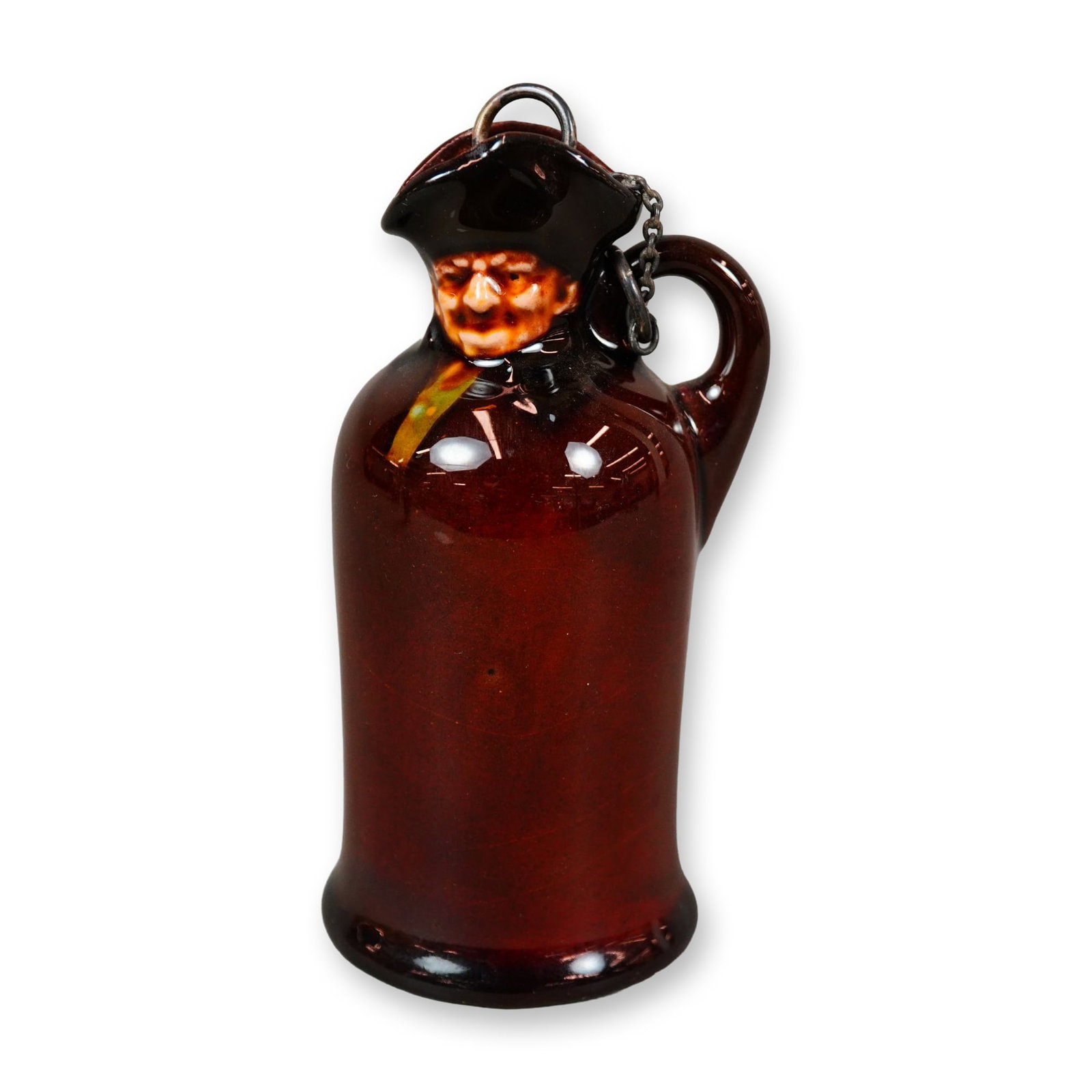 Royal Doulton Kingsware Miniature Flask, Watchman: A porcelain figural flask finished in Royal Doulton’s rich Kingsware brown glaze, modeled as the character Watchman. The flask retains its original cork stopper, fitted with a George Betjemann & Son