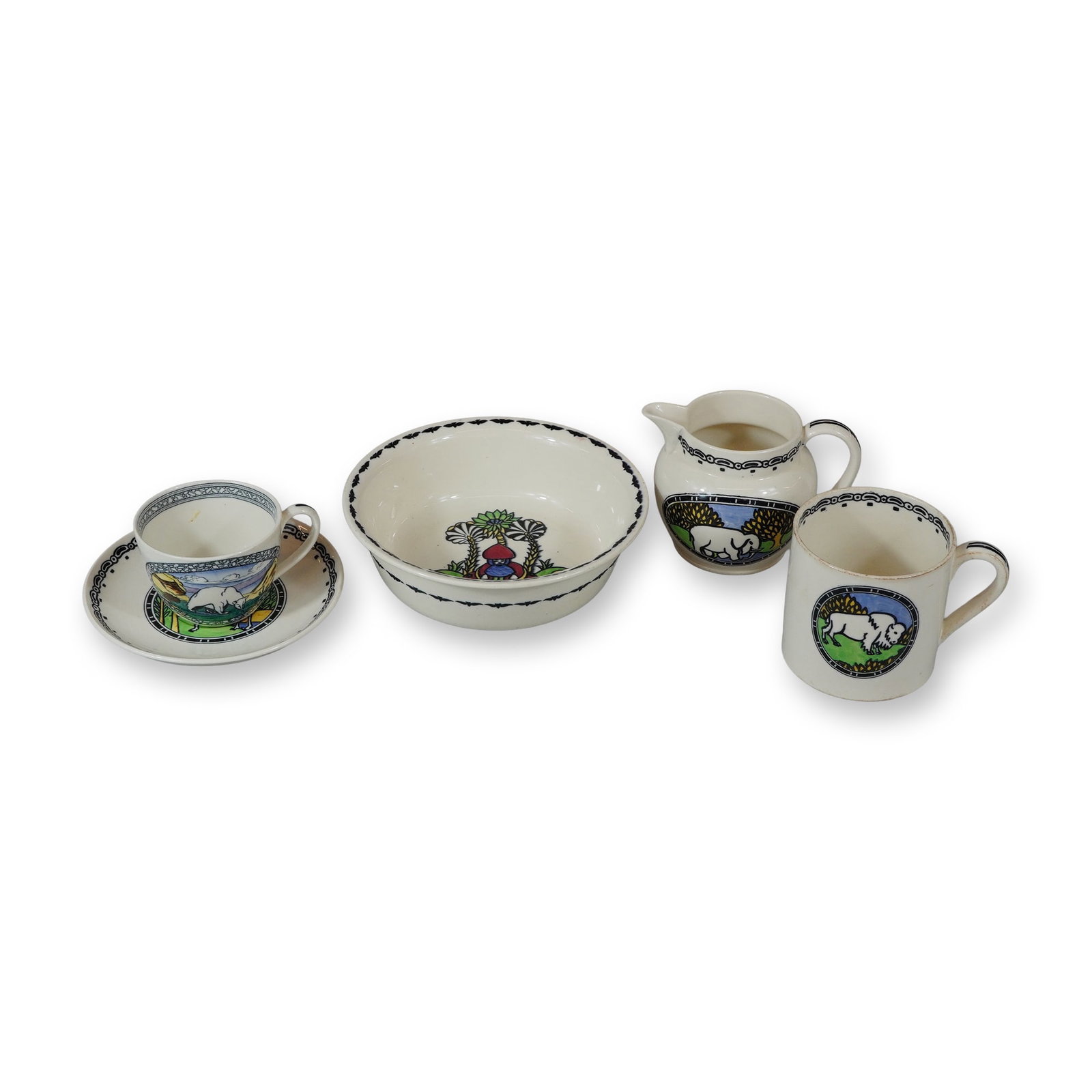 A 6 Piece Wedgwood Daisy Makeig-Jones Earthenware Nursery Ware Set: This 6 piece set of Wedgwood earthenware nursery ware was designed by Susannah Margaretta (Daisy) Makeig-Jones between circa 1915 and 1925. The collection is crafted from cream-colored earthenware and
