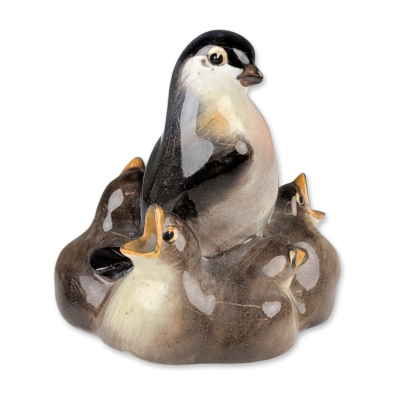 Royal Doulton Porcelain Figurine, Bird with Five Chicks HN214: This glazed porcelain figure depicts an adult swallow perched attentively among five chicks with open beaks. Executed in a naturalistic palette, the piece features black, brown, and soft pink tones, h