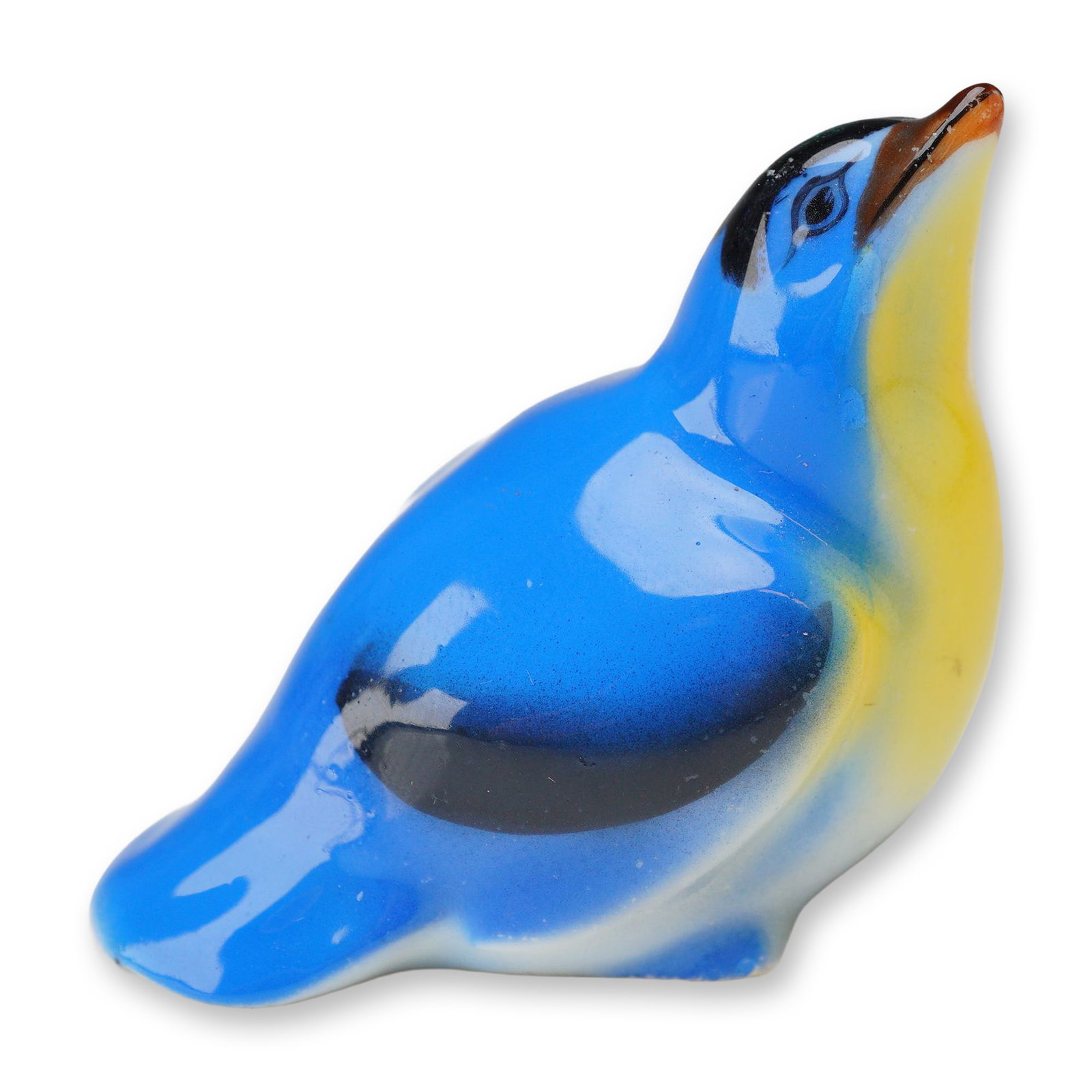 Royal Doulton Ceramic Figurine, Fledgling HN145C: Depicting a bluebird fledgling with its head tilted upward. The figure features a bright blue glazed body with a yellow breast, black highlights on the wings and head, and green and brown accents on t