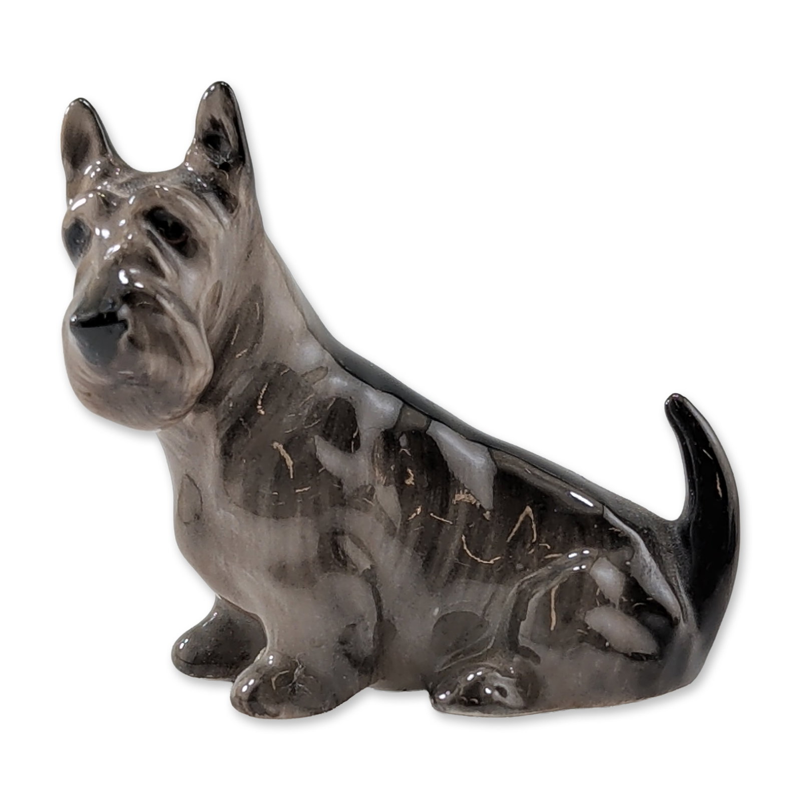 Royal Doulton Bone China Miniature Figurine, Scottish Terrier K18: Featuring a seated pose and mottled gray and black brindle coat. Base includes green Royal Doulton backstamp. Dimensions: 2.5"L x 1.25"W x 2.25"H Weight: 1.4 oz.