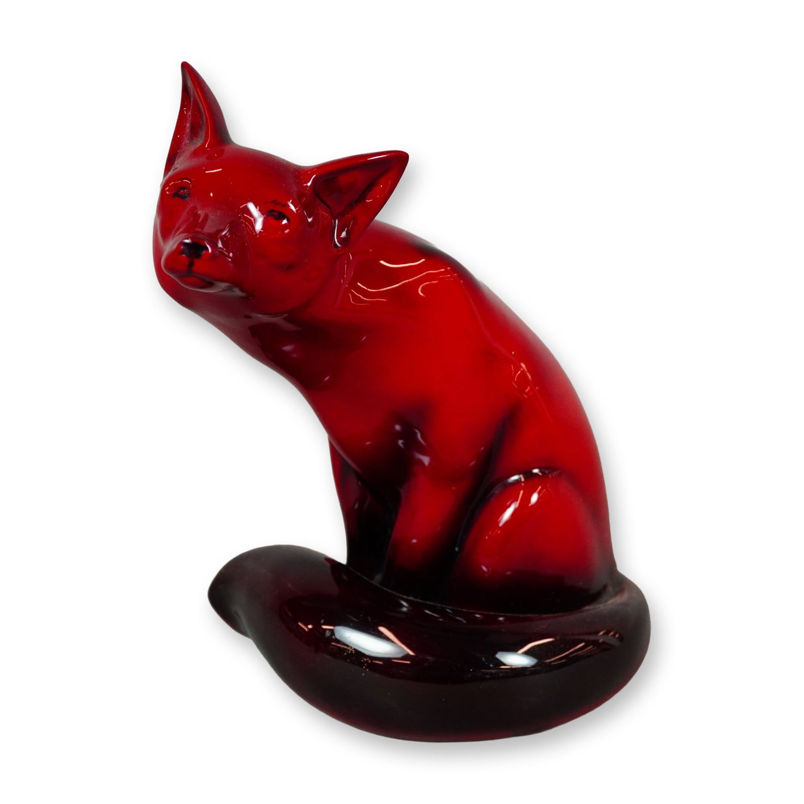 Royal Doulton Flambe Figurine, Fox Seated HN130: Red flambe-glazed seated fox figure, depicted with its head gently tilted to one side and its tail curled around the front of the body. Finished in a rich flambe glaze and bearing the Royal Doulton Fl