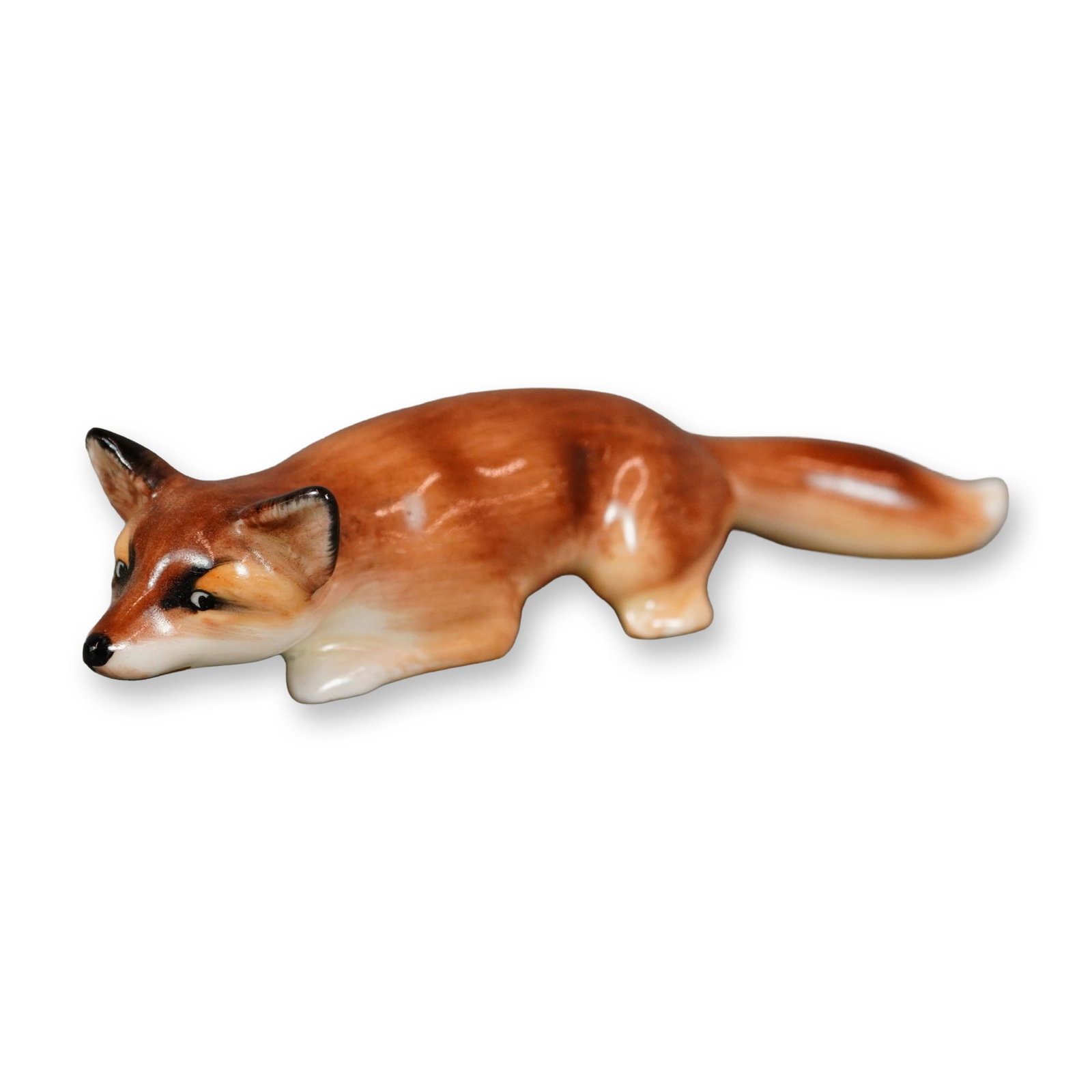 Royal Doulton Bone China Figurine, Fox Stalking HN147E: Hand-painted Royal Doulton figure depicting a fox in naturalistic shades of brown, modeled in a low, crouching pose. The underside bears the Royal Doulton backstamp. Dimensions: 5.25"L x 1.25"W x 1"H 
