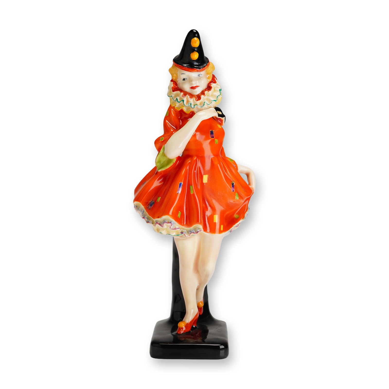 Royal Doulton Porcelain Figurine, Pierrette HN1391: Part of the Commedia dell'Arte series. Designed by Leslie Harradine. Art Deco figure in Pierrot costume leaning on a black pillar, wearing a conical hat with pom-poms and ruffled collar, red patterned
