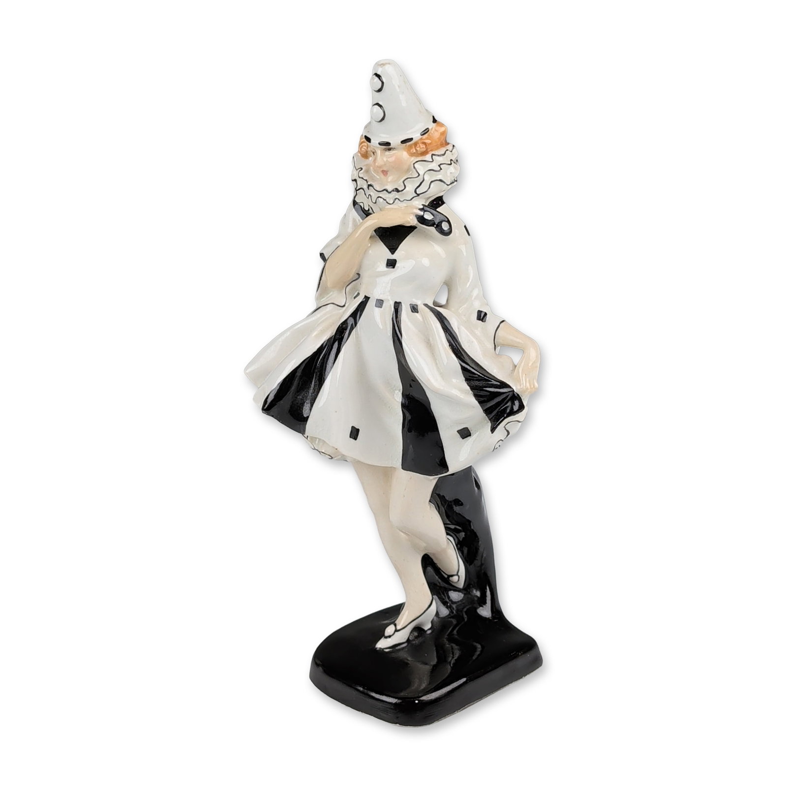 Royal Doulton Porcelain Figurine, Pierrette HN721: Design by Leslie Harradine. The figure depicts a dancing character from the Commedia dell’arte tradition dressed in a white costume accented with bold black stripes and square polka dots, featuring 