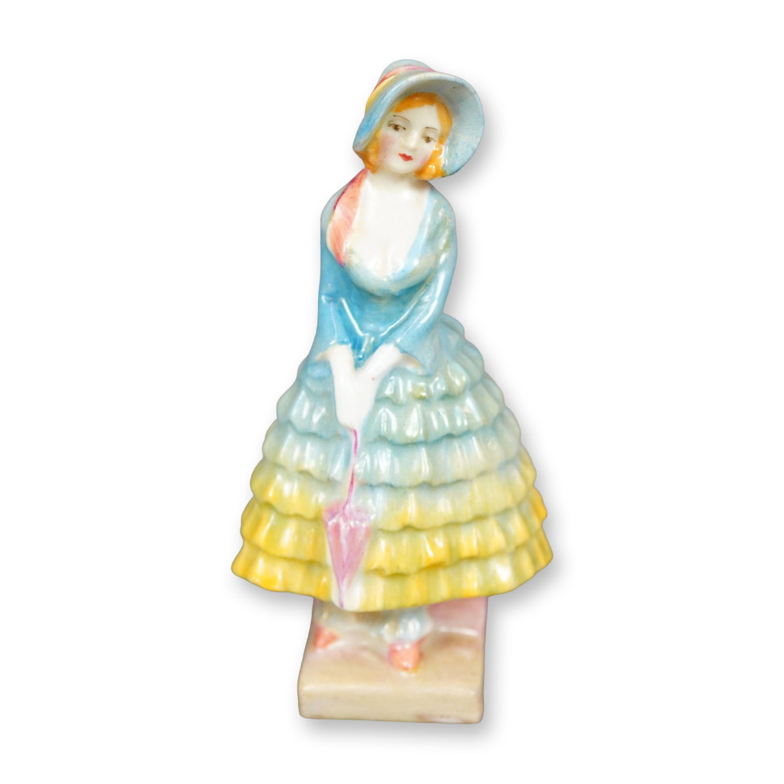 Royal Doulton Figurine, Priscilla M13: Hand painted figurine of a young woman in a blue-yellow ruffled gown, shown holding a pink umbrella. Royal Doulton backstamp. Dimensions: 2"L x 1.75"W x 4"H Manufacturer or Brand: Royal Doulton Countr