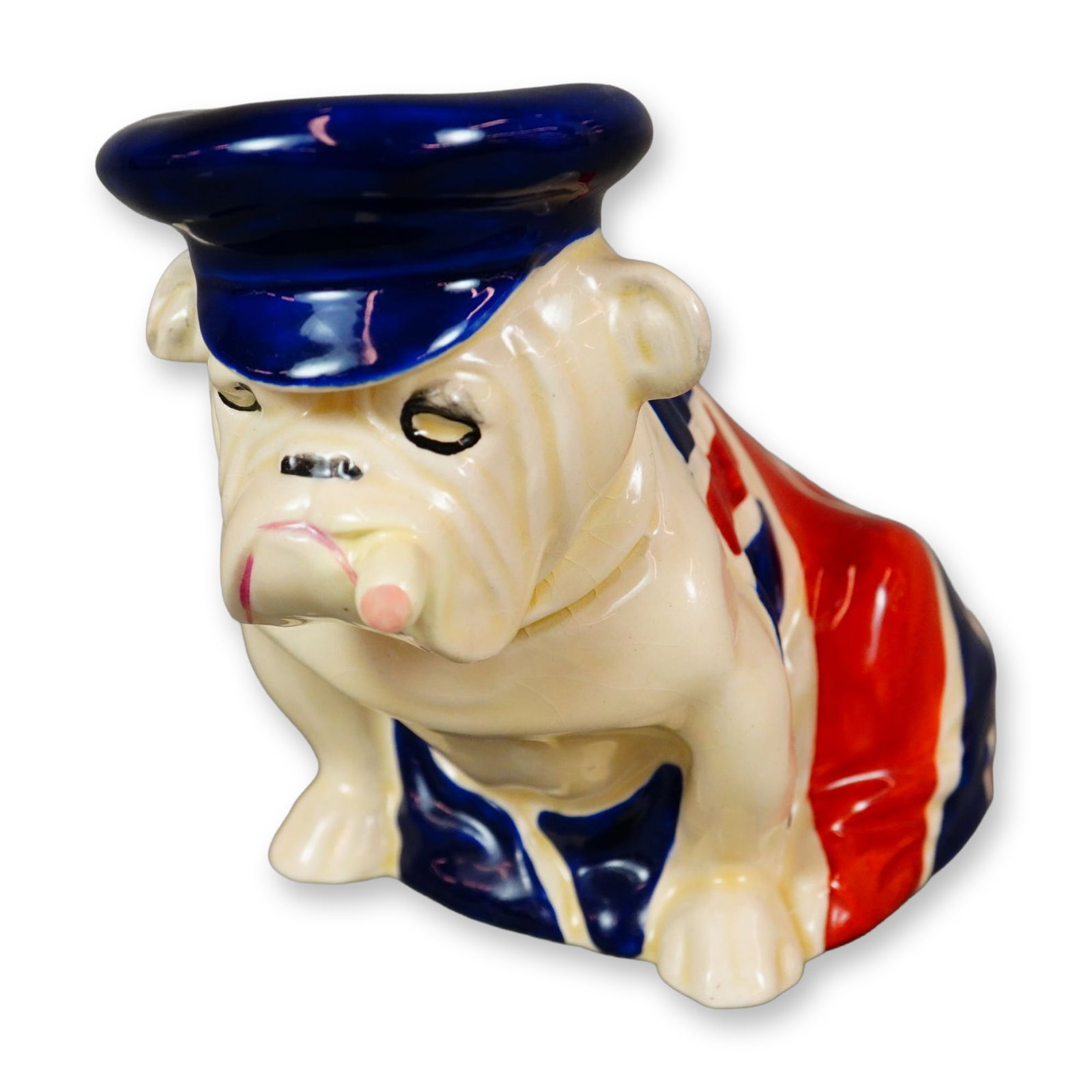 Royal Doulton Porcelain Medium Figurine, Bulldog Draped in Union Jack with Trinity Cap D6182: The bulldog became a symbol of British resilience, courage, and steadfast determination, and it continues to be recognized as a national emblem of Great Britain. This figure depicts a proud bulldog dr