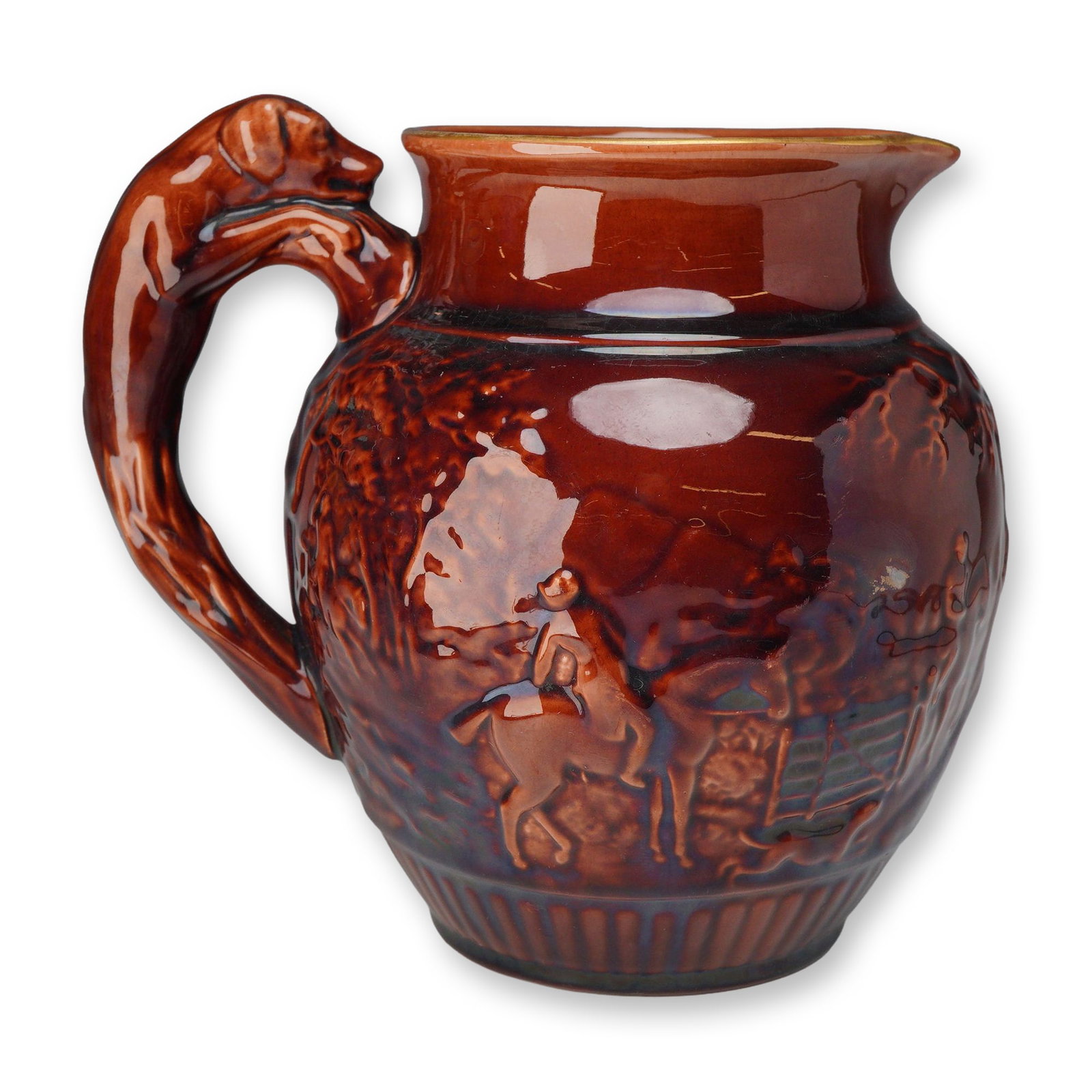Wedgwood Rockingham Glazed Hunt Scene Pitcher with Hound Handle: A Wedgwood Rockingham-glazed earthenware pitcher featuring a molded hound handle and relief-decorated hunt scene. The bulbous body displays a continuous landscape in high relief, depicting hunters on 