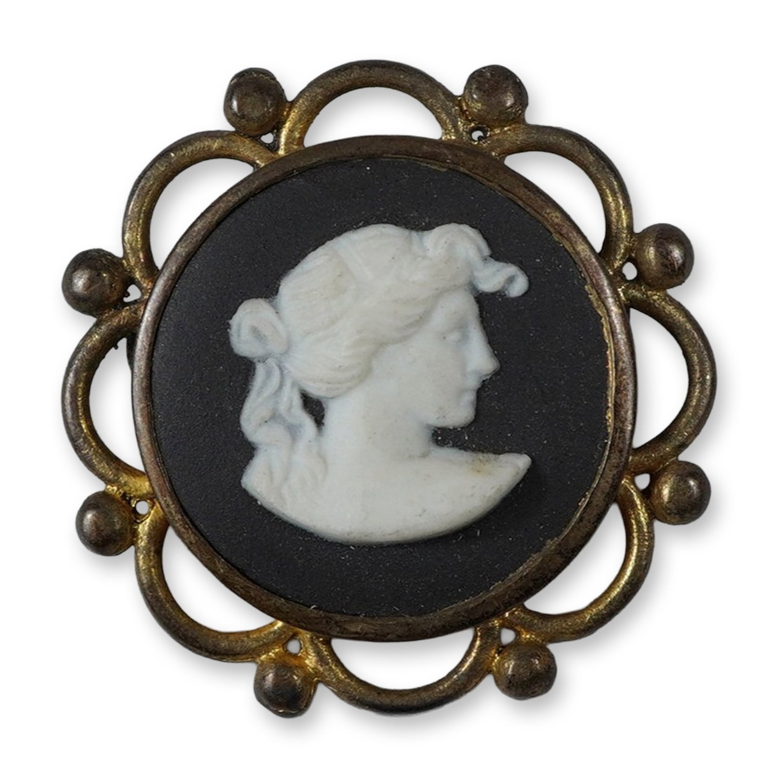 Wedgwood Black Jasperware and Gold Plated Sterling Silver Cameo Brooch: This Wedgwood black jasperware cameo brooch features a circular plaque with a classical female profile in white bas-relief. The jasperware is set into a decorative 9 karat yellow gold-plated sterling 