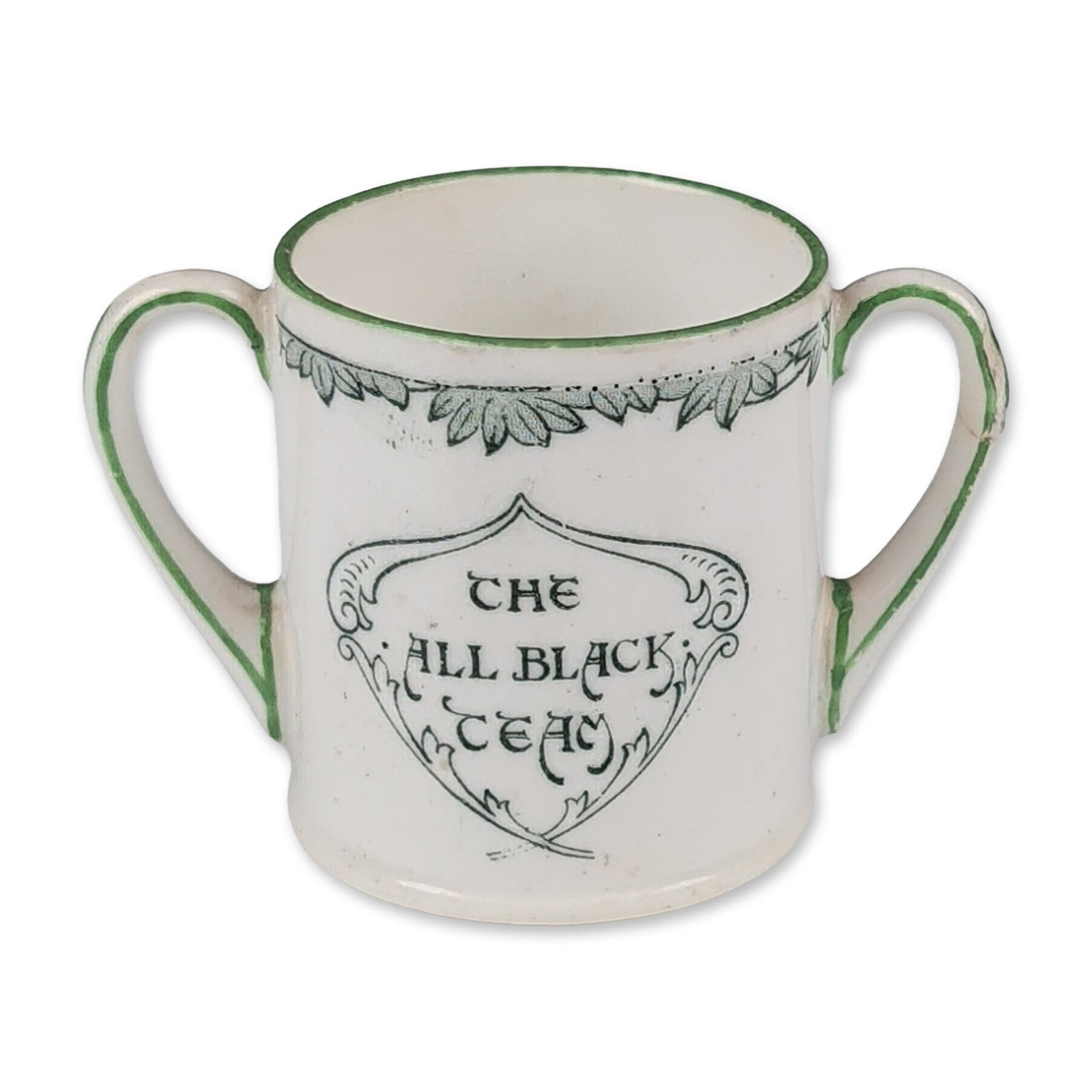 Royal Doulton All Black Team Seriesware Porcelain Miniature Tyg, Next Man In: Miniature two-handled tyg in glazed ceramic, part of the All Black Team series featuring transfer-printed decorations in green and polychrome. One side displays a stylized cartouche inscribed THE ALL 