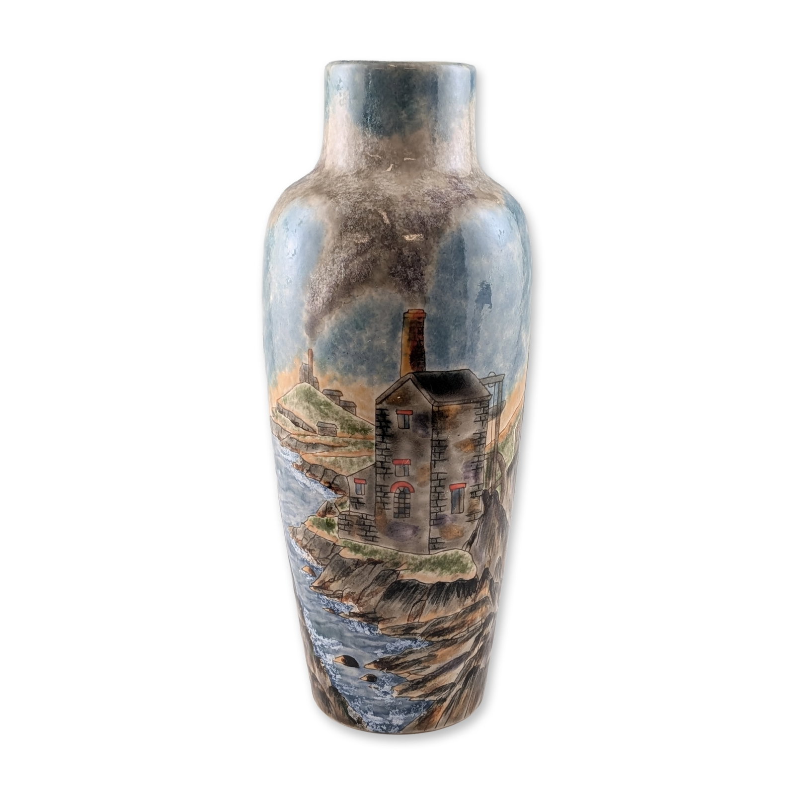 Cobridge Stoneware by Philip Gibson Cornish Tin Mine Vase: A tapering cylindrical stoneware vase featuring a hand-painted continuous landscape of a rugged coastline with historic Cornish tin mine engine houses and smoking chimneys. The scene is rendered in an