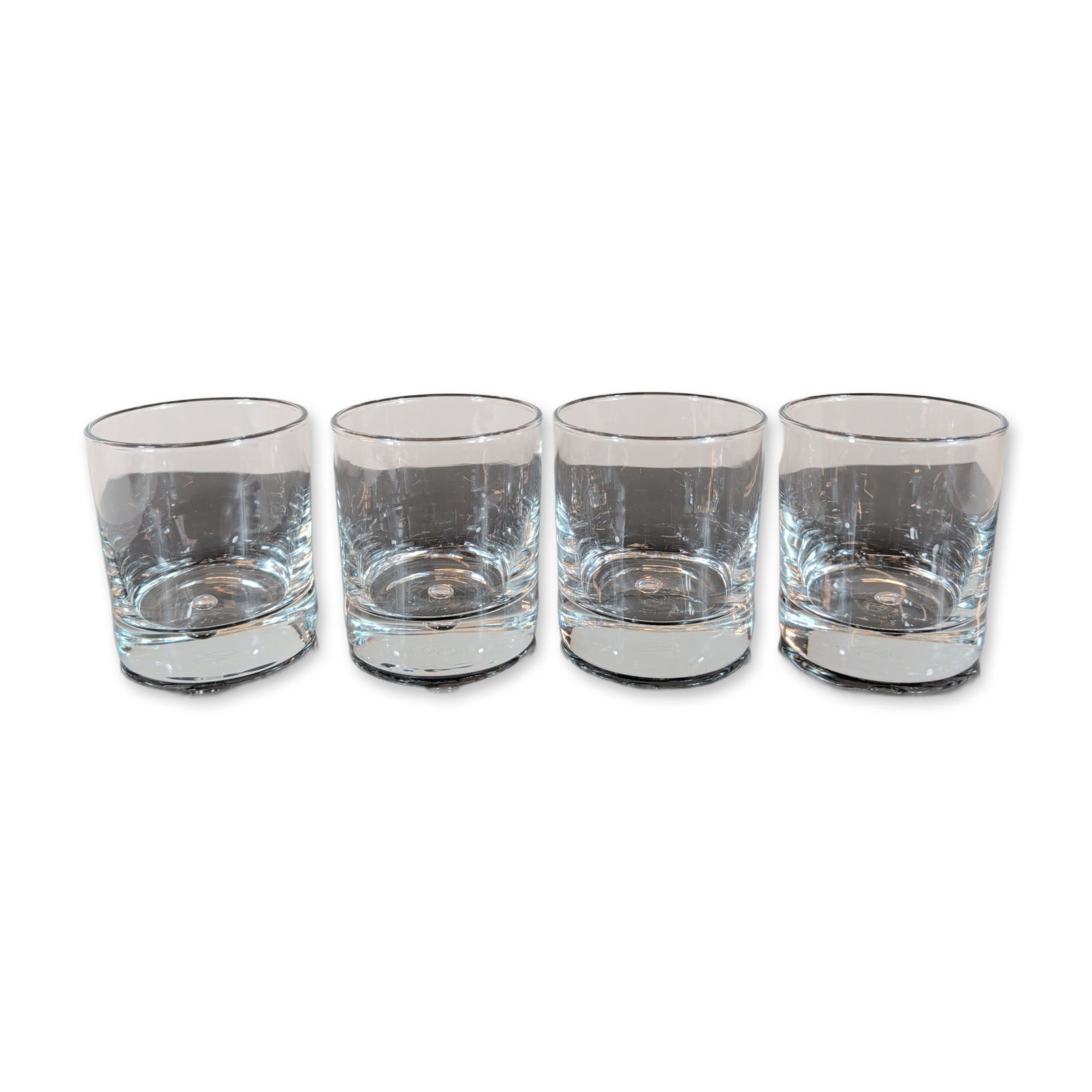 4pc Pasabahce Turkey Crystal Old Fashioned Glasses: Set of four Pasabahce drinking glasses in clear colorless crystal. Each glass features a cylindrical form with a heavy, weighted base detailed with an ergonomic curved indentation. The underside of ea