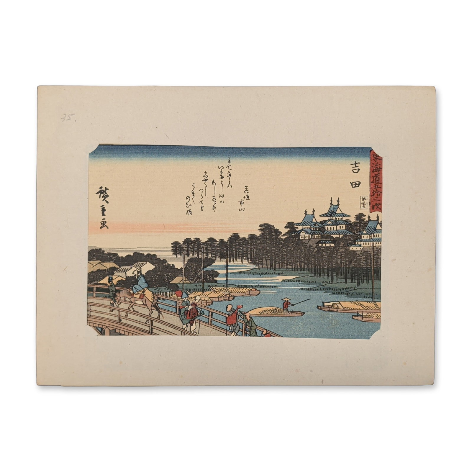 After Utagawa Hiroshige (Japanese 1797-1858) Yoshida from a Fifty-three Stations of the Tokaido: A group of travelers and porters on foot cross a large wooden bridge leading into a scenic post town dominated by a multi-tiered castle complex rising beside a wide river channel. Small river boats na
