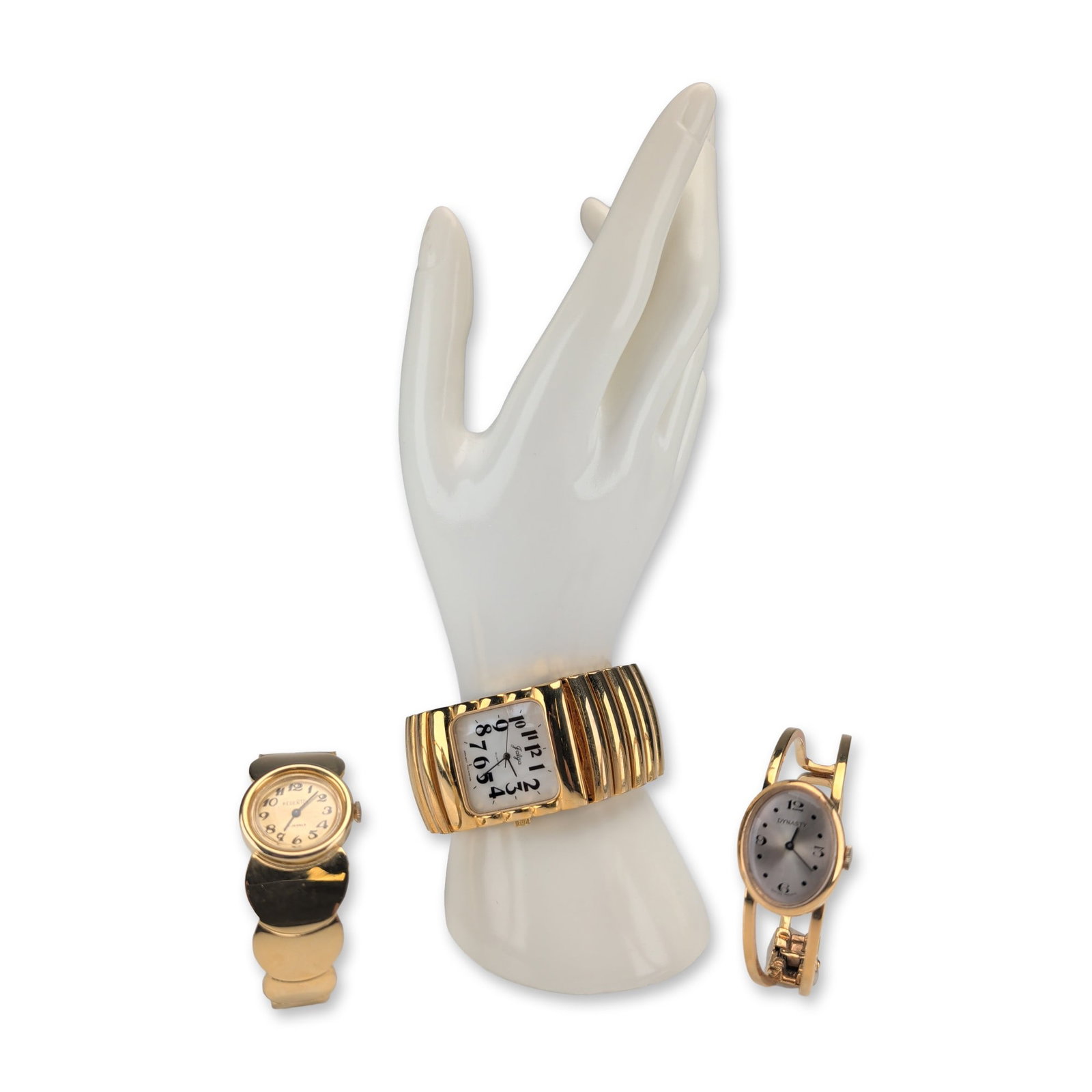 3pc Vintage Gold-Tone Wristwatches: Three vintage women's dress watches featuring gold-tone cases and decorative bracelets. The group includes a Swiss-made Dynasty bangle watch with an oval silver-tone sunburst dial, Arabic numerals at 