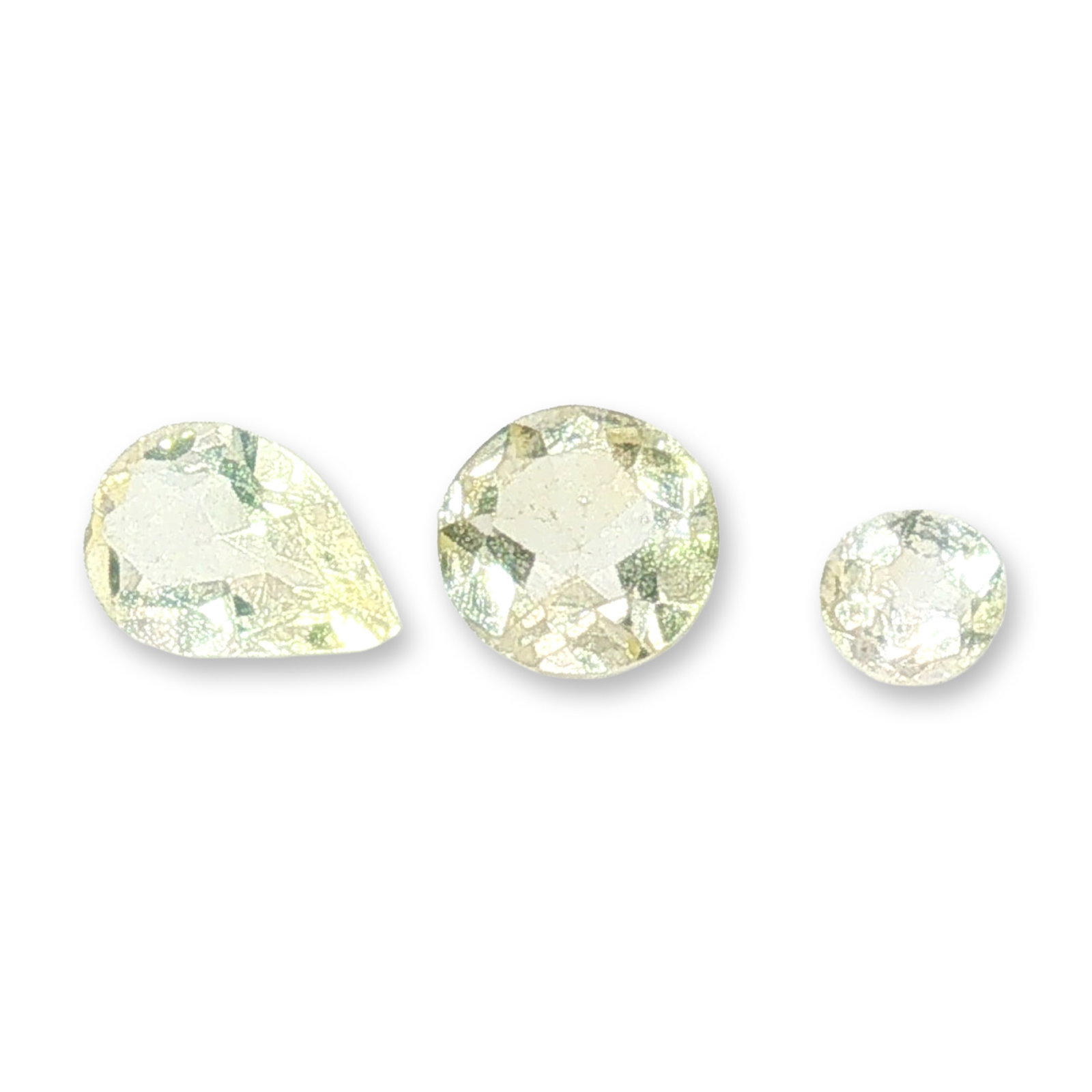 Three Loose Yellow and Near-Colorless Citrine: Trio of loose Citrine including one pear-cut and two round-cut examples. The pear-cut citrine appears to be a light yellow color with visible internal characteristics. The central round-cut citrine di