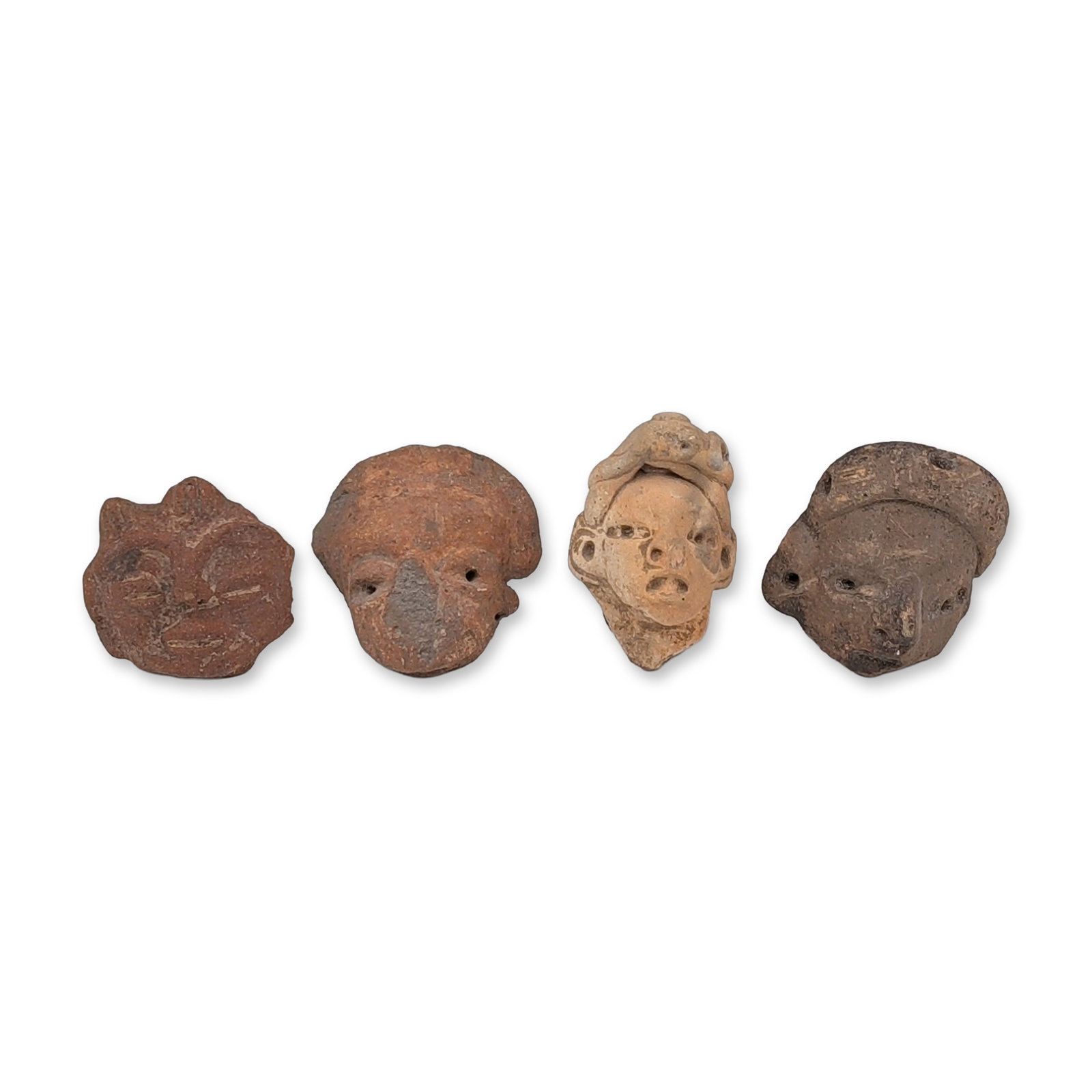 4pc Pre-Columbian Terracotta Figure Heads: Group of four hand-modeled ceramic figurine head fragments exhibiting various regional artistic traditions. The collection includes a head with coffee-bean-shape eyes and a raised brow ridge, as well 