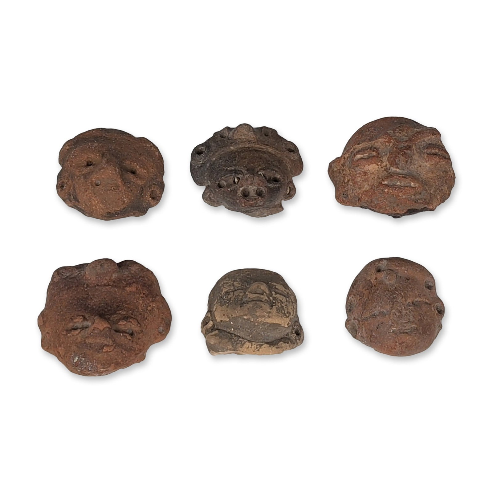 6pc Pre-Columbian Terracotta Heads: The group comprises six individual head fragments in various fired ceramic clays, including reddish-brown and grayish-brown terracotta. Features include circular ear spools, recessed or slit eyes, and