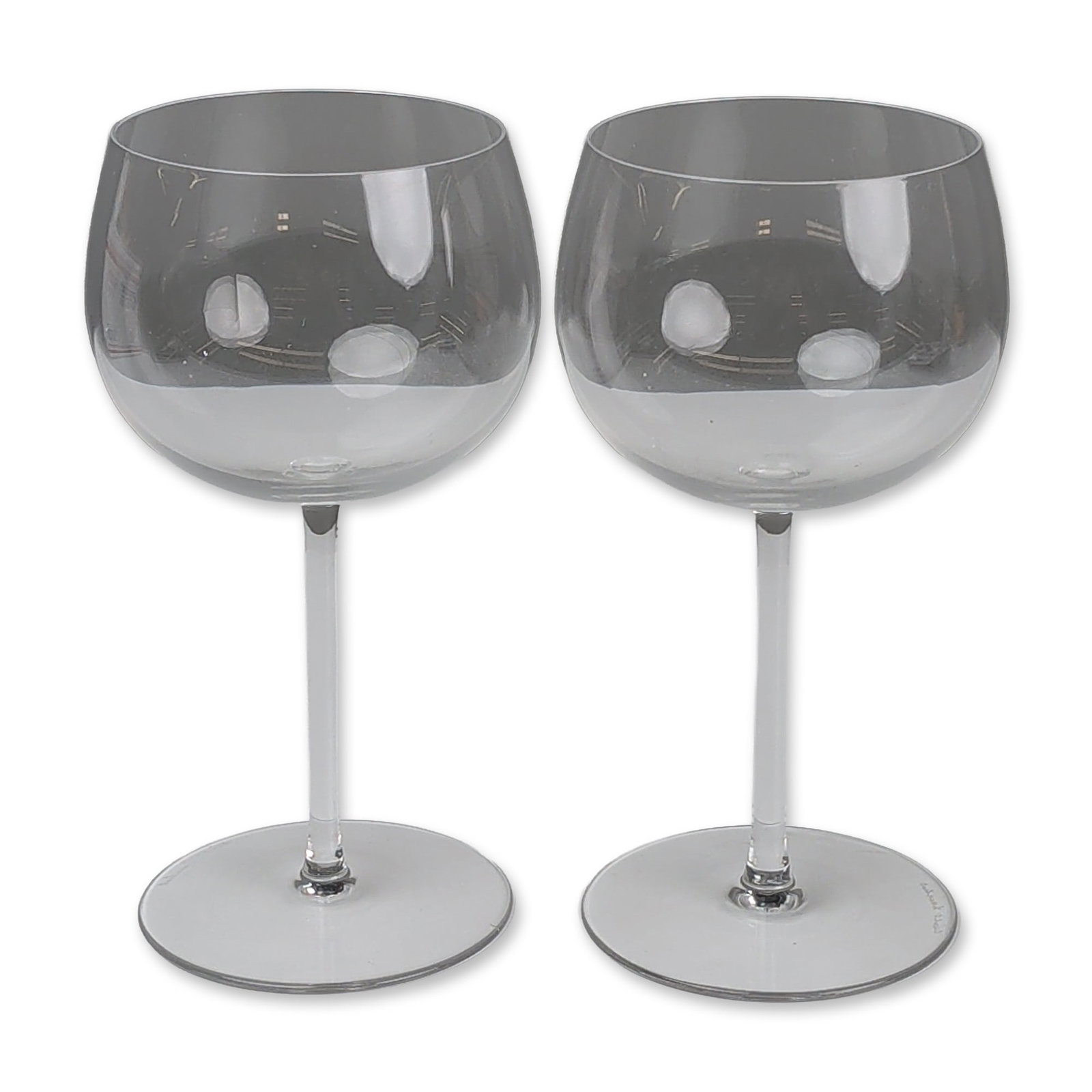 Pair of Val Saint Lambert Crystal Balloon Glasses: Pair of balloon-style wine glasses in clear lead crystal, featuring large rounded bowls with tapered rims, slender straight stems, and flat circular feet. Each piece bears an etched script signature