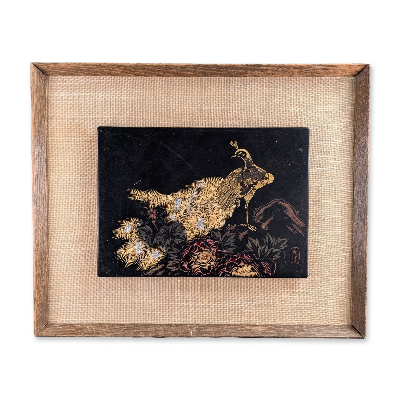 Japanese Lacquer Peacock Decorative Panel w/ Red Seal: Japanese black lacquer decorative panel that depicts a peacock standing among blooming peonies and foliage, executed in gold and silver toned metallic pigments using incised and sprinkled techniques. 