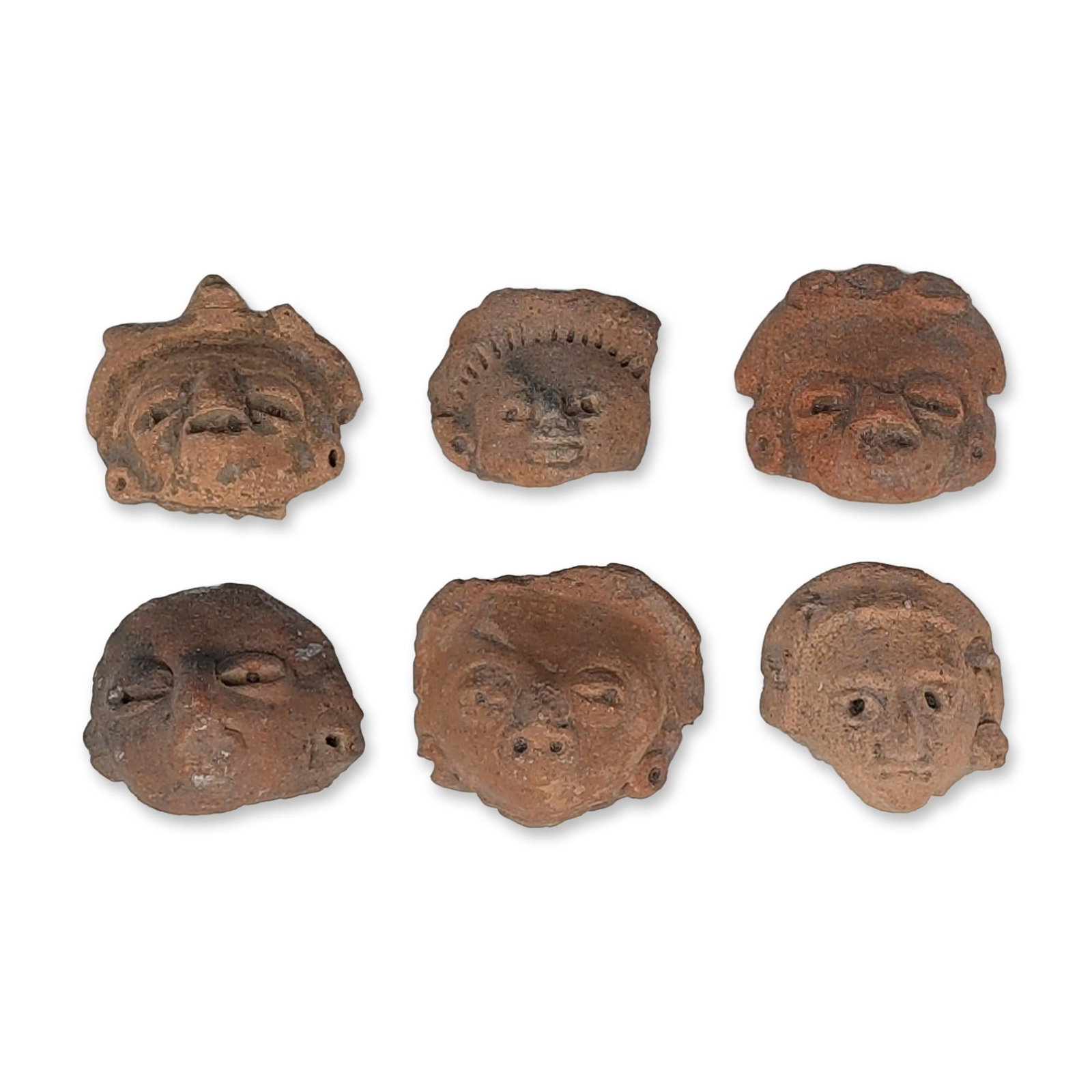 6pc Pre-Columbian Terracotta Figure Heads: Group of six anthropomorphic figurine heads in terracotta, including coffee-bean shape eyes, prominent ear spools, and elaborate headdresses. The collection displays diverse hairstyles, including