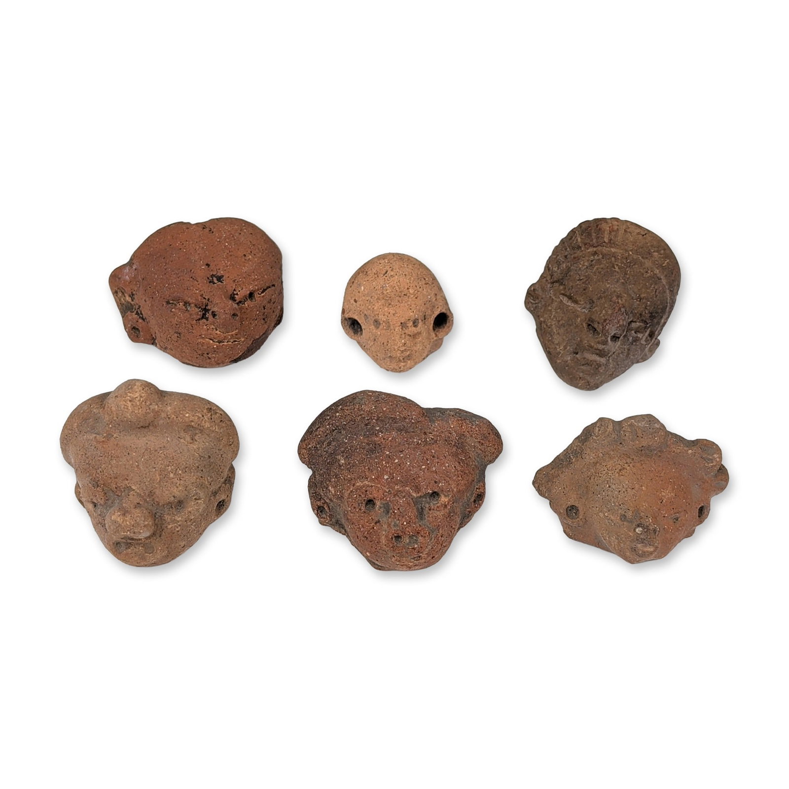 6pc Pre-Columbian Terracotta Heads: Collection of six hand-modeled terracotta figurine heads, featuring a variety of anthropomorphic facial expressions and decorative headpieces. The group includes examples with punctate eyes,