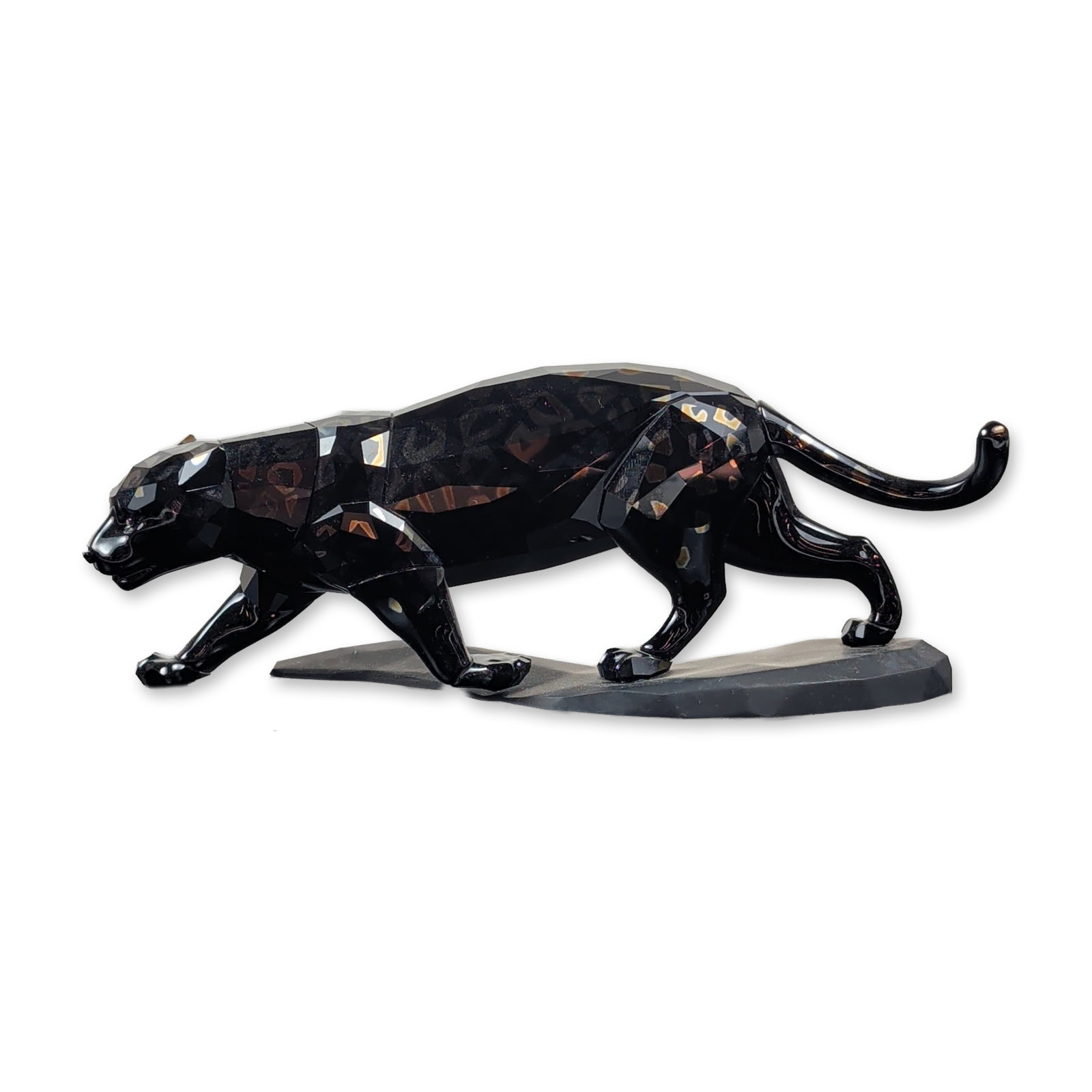 Swarovski Faceted Jaguar Jet Crystal Figurine: This designer crystal statement figurine depicts a dynamic jaguar captured mid-stride atop a dark display plinth. The animal form is sculpted from multi-faceted Jet Hematite crystal finished with a sp