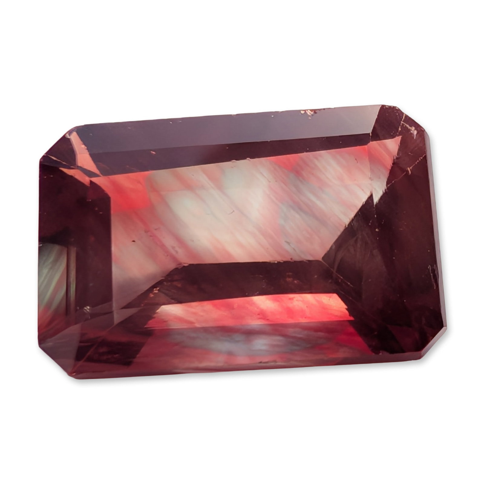 Emerald Cut Bicolor Pink Stone: Loose stone, rectangular emerald-cut, featuring distinct color zoning from deep purplish-pink to pale blue and white. The stone exhibits internal parallel growth zoning and fine silk-like inclusions. 