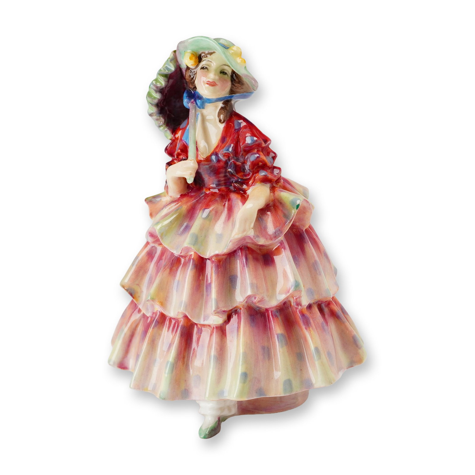 Royal Doulton Bone China Figurine, Hinged Parasol HN1578: Designed by Leslie Harradine. The glazed bone china figure depicts a woman in a tiered, ruffled gown featuring a red bodice and multicolored skirt with blue polka dots. She wears a wide-brimmed green 