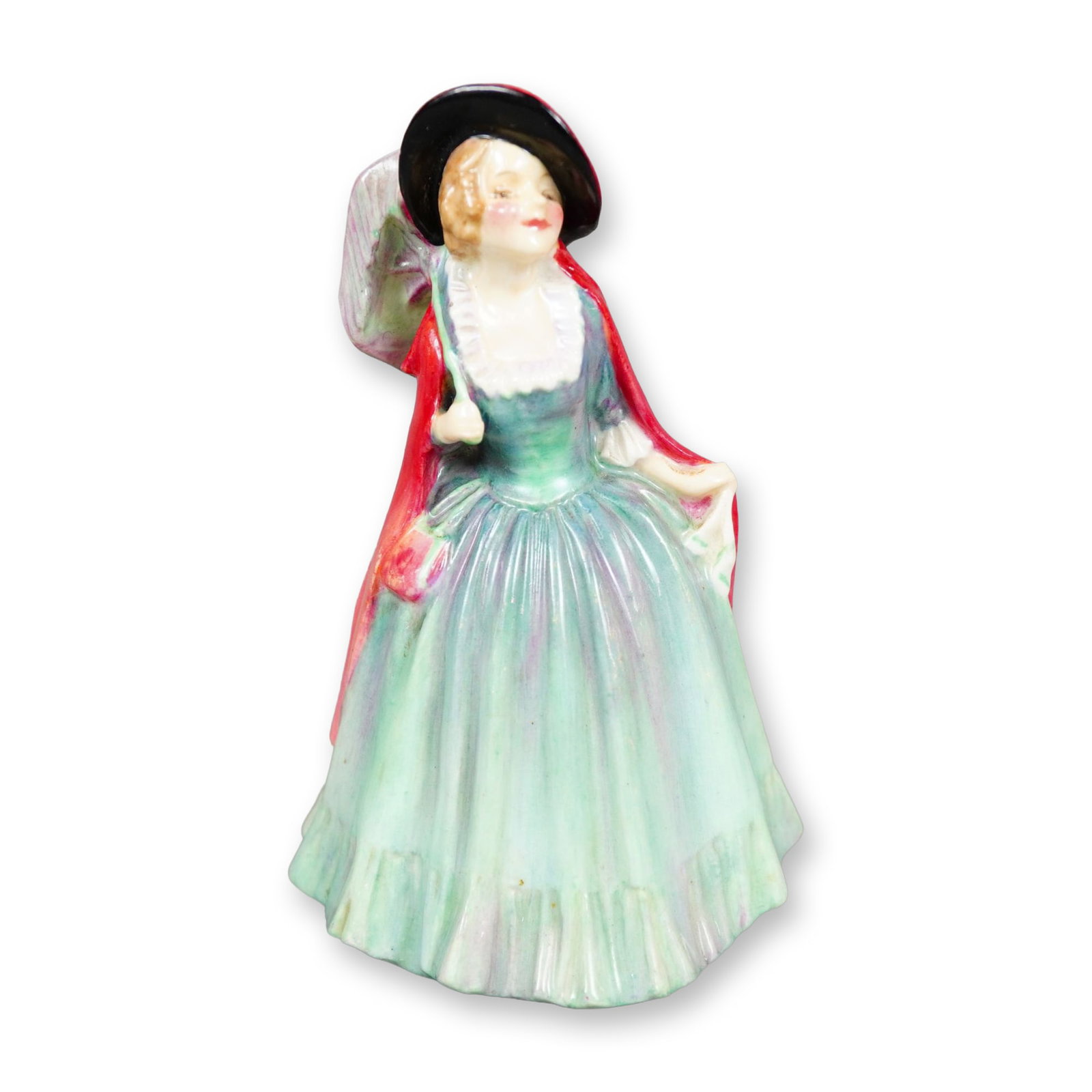 Royal Doulton Figurine, Mirabel M74: Hand painted figure of a young woman in a green gown with blue and purple accents. She is also wearing a dark pink cape and hat. She is shown holding a green parasol with purple accents over her shoul