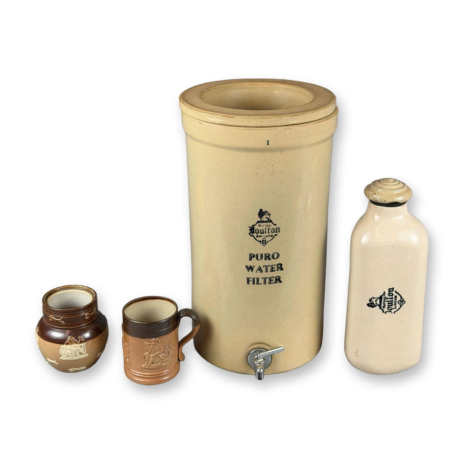 4pc Royal Doulton Lambeth Stoneware Water Filter, Hot Water Bottle, Mug, and Jar: Collection of English stoneware pottery comprising a lidless Royal Doulton Puro Water Filter with Royal Doulton logo to the front, a Royal Doulton hot water warmer with Royal Doulton logo, a two-tone 