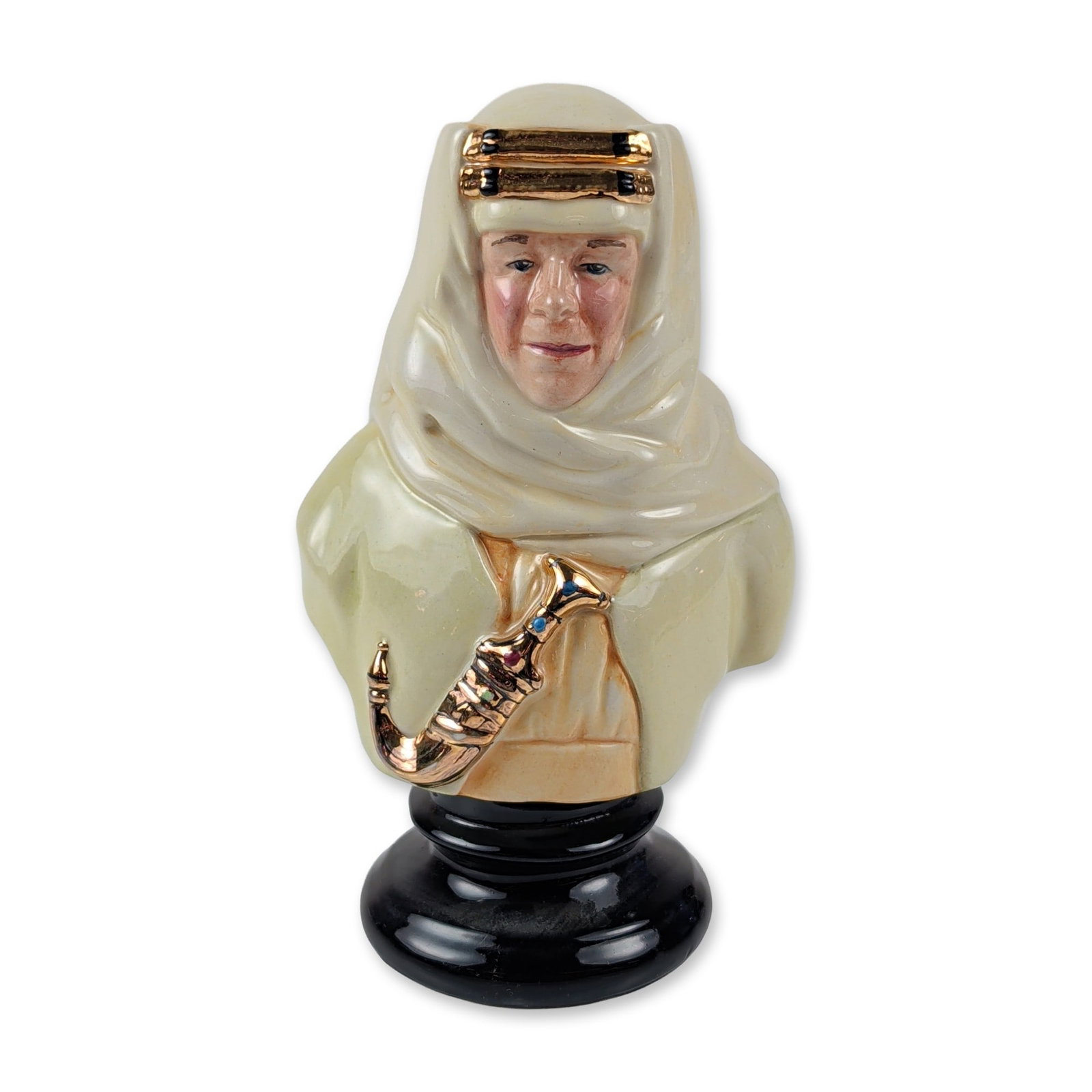 Michael Sutty Porcelain Lawrence of Arabia Bust: Michael Sutty fine china bust depicting T.E. Lawrence in traditional Arab attire. The hand-painted glazed porcelain figure shows the subject in a white keffiyeh secured by a double-strand gold luster 
