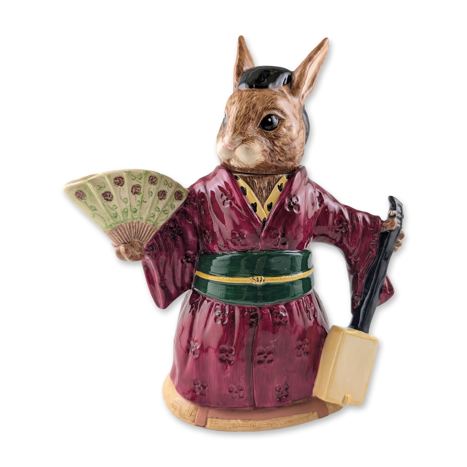 Royal Doulton Bunnykins Prototype Design Original Sample Teapot, Geisha Girl D7126: This glazed ceramic lidded vessel features an anthropomorphic rabbit in traditional Japanese attire, including a burgundy floral-motif kimono and a green obi with a gold-toned clasp. The figure holds 