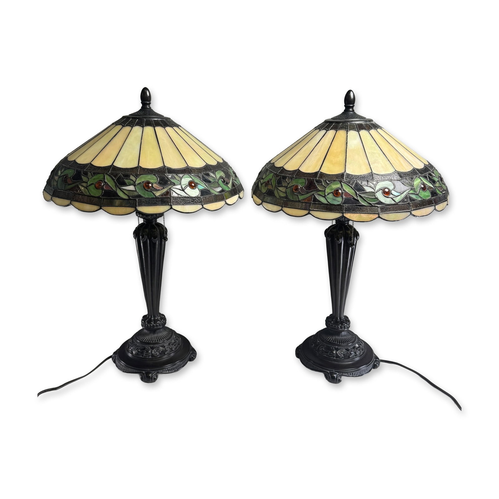 Pair of Art Nouveau Style Stained Glass Table Lamps: Art Nouveau style pair of table lamps in stained glass and cast metal. The lead-soldered shades feature radiating cream slag glass panels above a stylized foliate vine border in green and brown glass 
