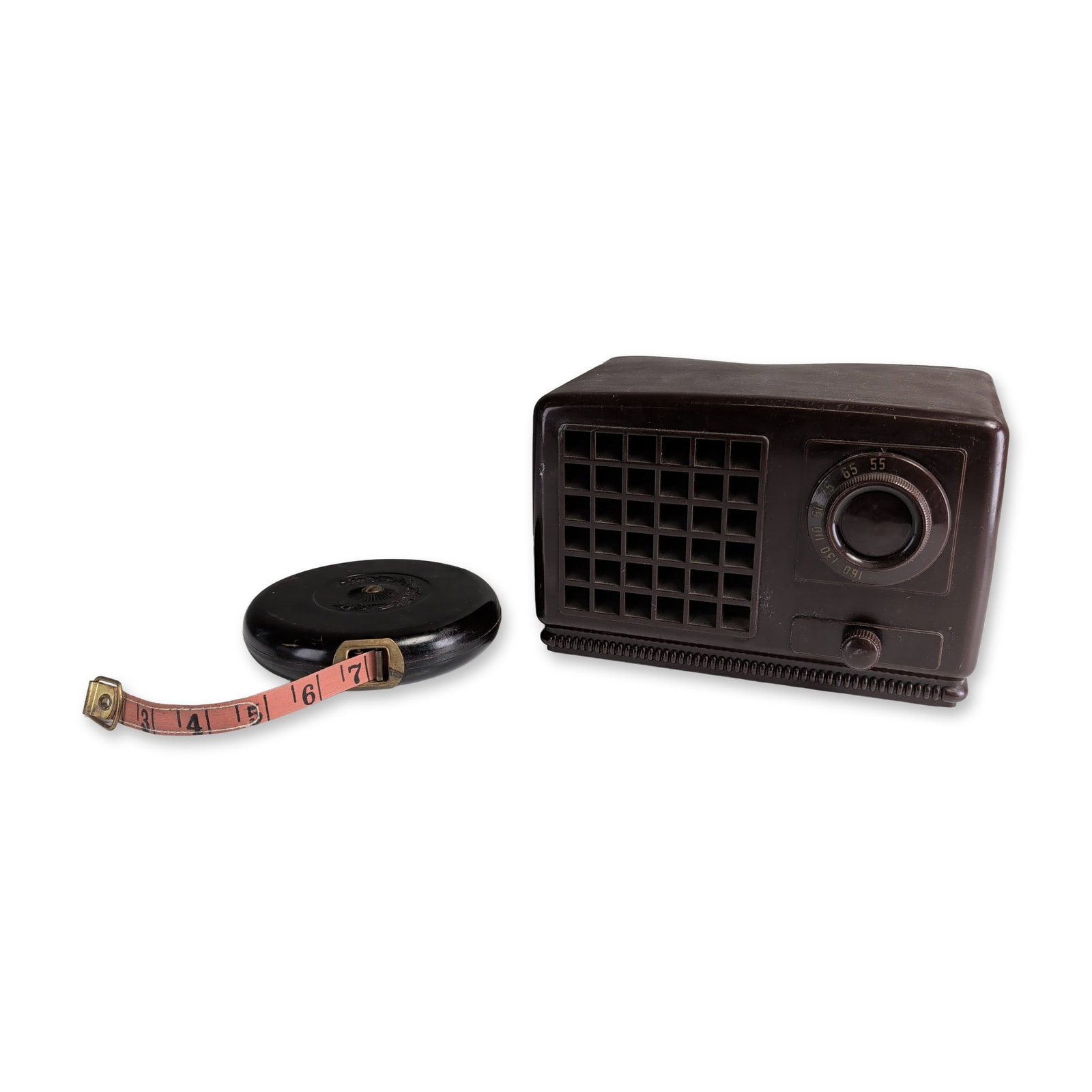 Firestone Model 4-A-68 Bakelite Radio & Tricle Bakelite and Cloth Measuring Tape: Firestone Tire and Rubber Co. tabletop vacuum tube AM radio and a large retractable Tricle bakelite and cloth tape measure. The radio features a dark brown Bakelite cabinet with a circular frequency d