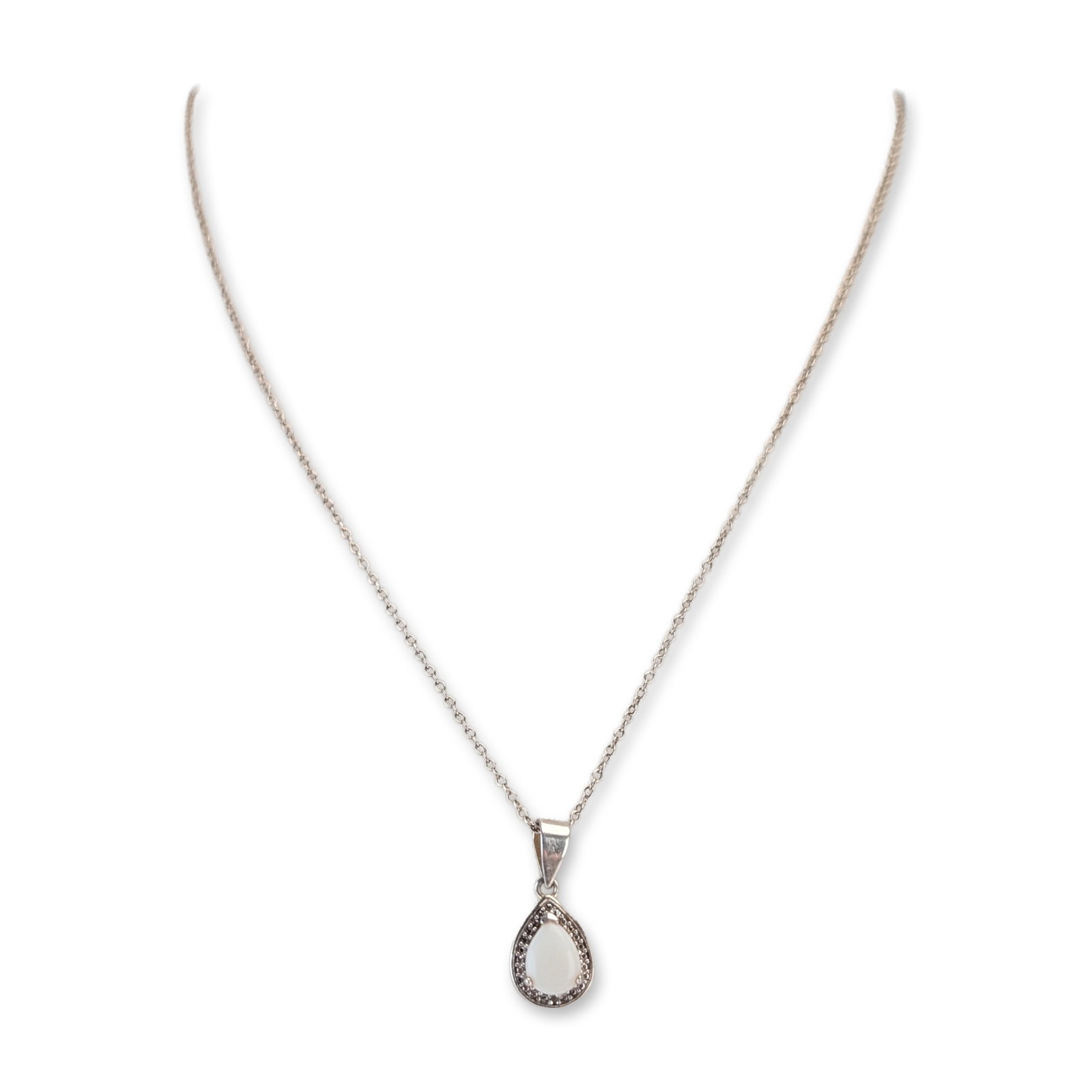 Sterling Silver Teardrop Pendant Necklace: A sterling silver pendant necklace, featuring a teardrop-shaped pendant set with a central pear-cut white cabochon and a halo of small bead accents. The pendant is suspended from a polished tapered