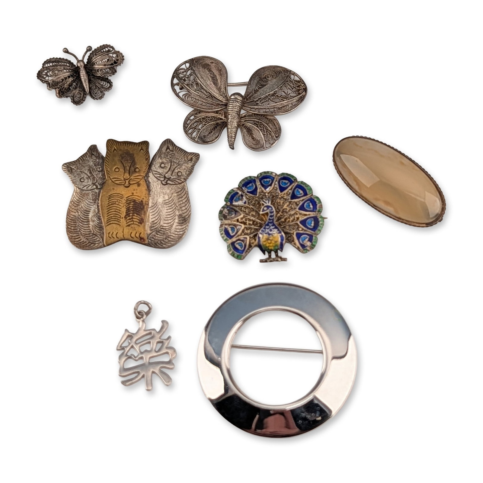 7pc Collection of Vintage Jewelry Brooches and Pendant: Group of vintage jewelry items featuring a variety of motifs and materials. The collection includes a circular brooch in polished silver-toned metal with the reverse stamped (c) Vendome. An openwork p
