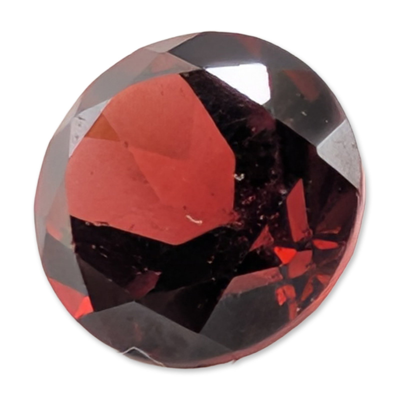 Round Faceted Garnet Loose Gemstone: Loose round faceted gemstone, appears to be a variety of garnet, featuring a deep brownish-red color with bright red flashes.Diameter: approximately 6mmWeight: 1.1 carats. Dimensions: 6mm