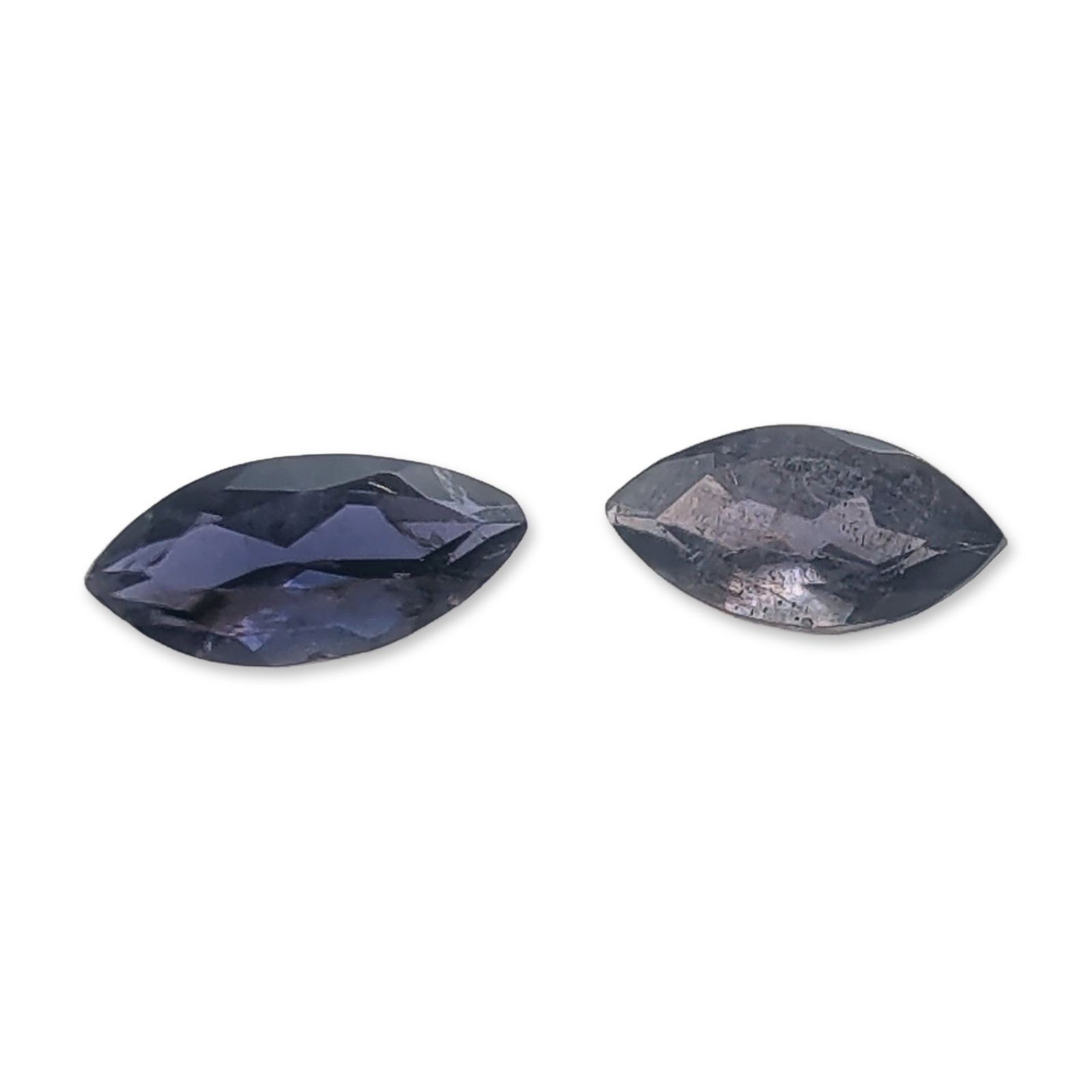 2pc Marquise Cut Iolite Gemstones: Pair of loose faceted iolite gemstones. Each stone is marquise cut with a deep violet-blue color, featuring visible internal feathers and particulate silk inclusions. Tested with Presidium Gem Tester