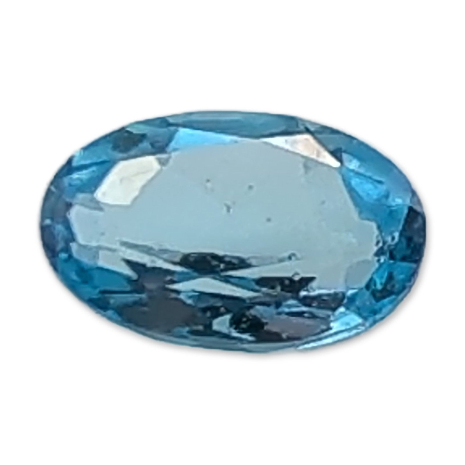 Oval Brilliant Cut Blue Topaz Gemstone: Faceted blue topaz gemstone in an oval brilliant cut. The stone displays a vibrant light blue color with high transparency and an eye-clean clarity. The faceting shows no visible internal inclusions