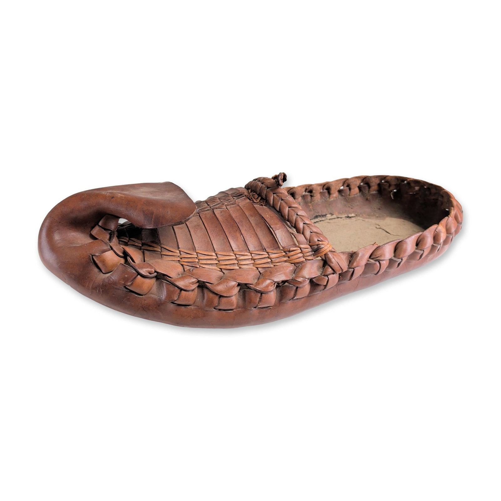 Balkan Style Leather Opanak Oversize Display Replica Shoe: Balkan style Opanak peasant shoe in reddish-brown leather used for display, featuring a hand-woven upper constructed from narrow hide strips and a prominent upward-curving toe. The footwear includes a