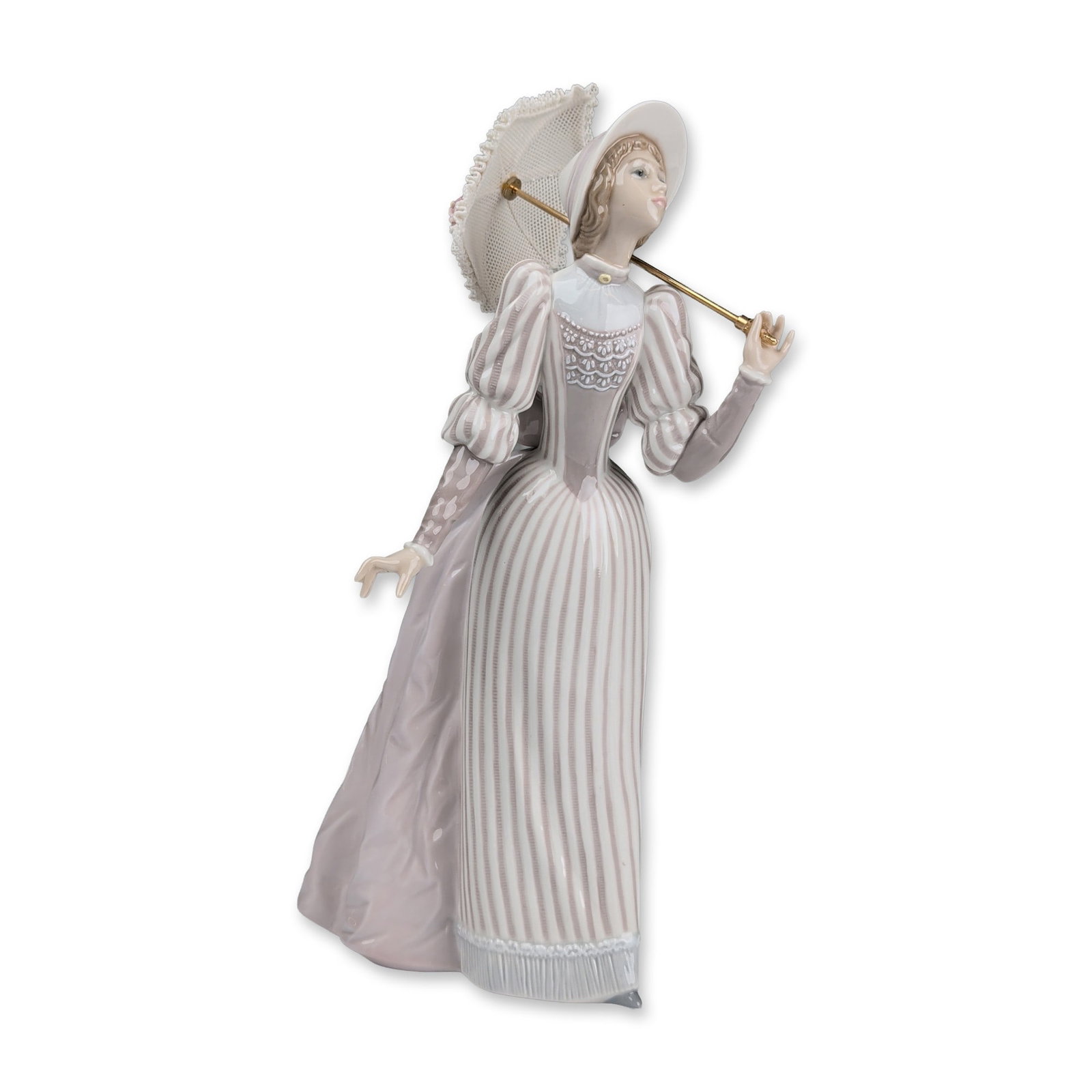 Lladro Porcelain Figurine, English Lady 01005324: Spanish glazed porcelain figurine depicting a woman in late Victorian style attire. The figure is modeled in a graceful pose wearing a wide-brimmed hat with a lavender ribbon and a high-collared bodic