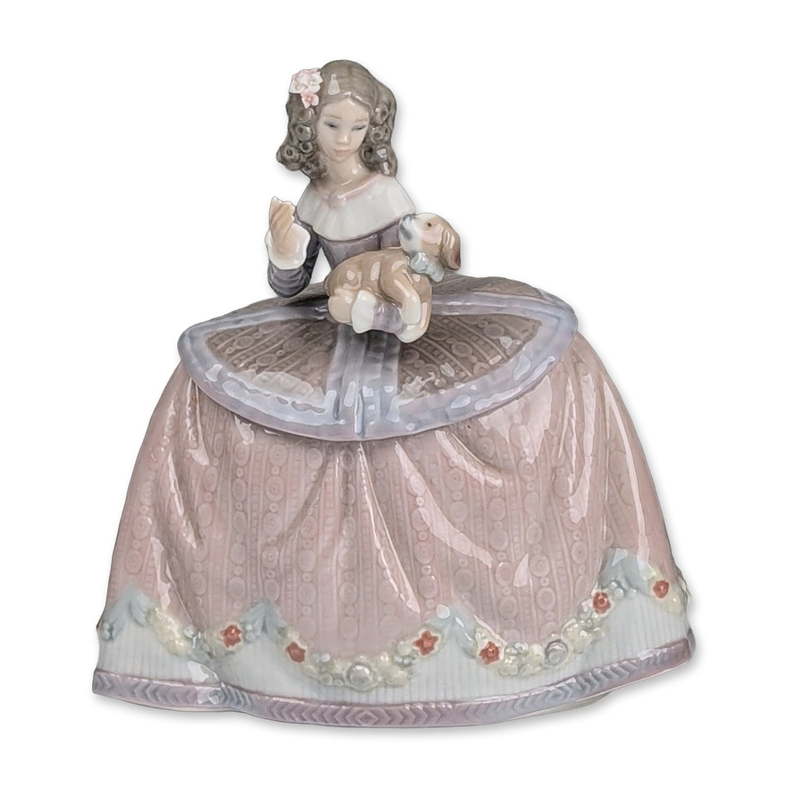 Lladro Spanish Figurine, Pilar 01005410: Spanish Lladro glazed porcelain figurine, model number 01005410, titled Pilar. The piece depicts a young girl in a wide-skirted pink gown featuring a circular textured lace pattern, holding a tan and 