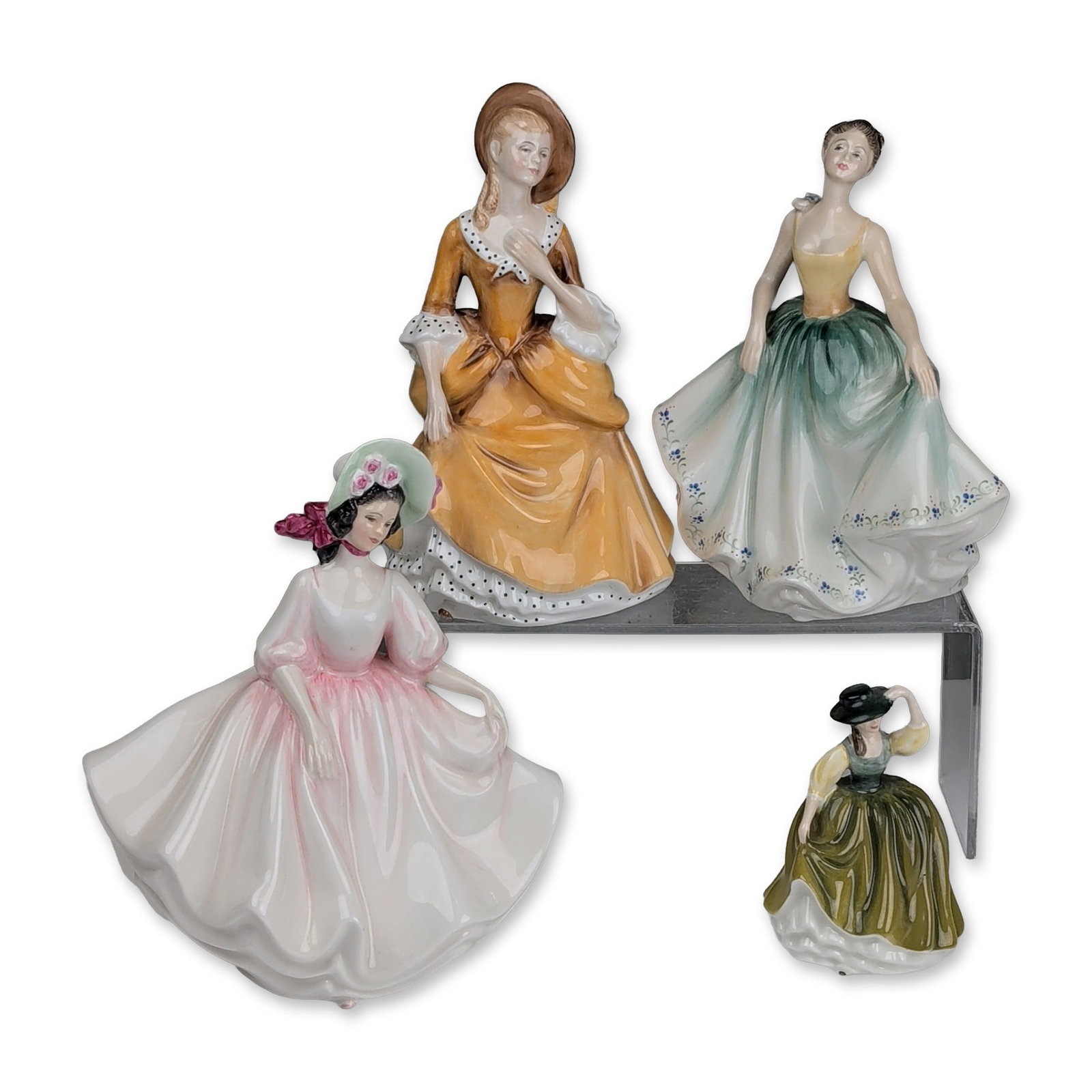 4pc Royal Doulton Porcelain Figurines, Sandra, Cynthia, Sunday Best, Buttercup: A group of four Royal Doulton glazed porcelain figurines in historical costumes: Sandra (HN 2275, 1968) depicting a standing woman in a yellow-orange gown and brown hat; Cynthia (HN 2440, 1971) depict