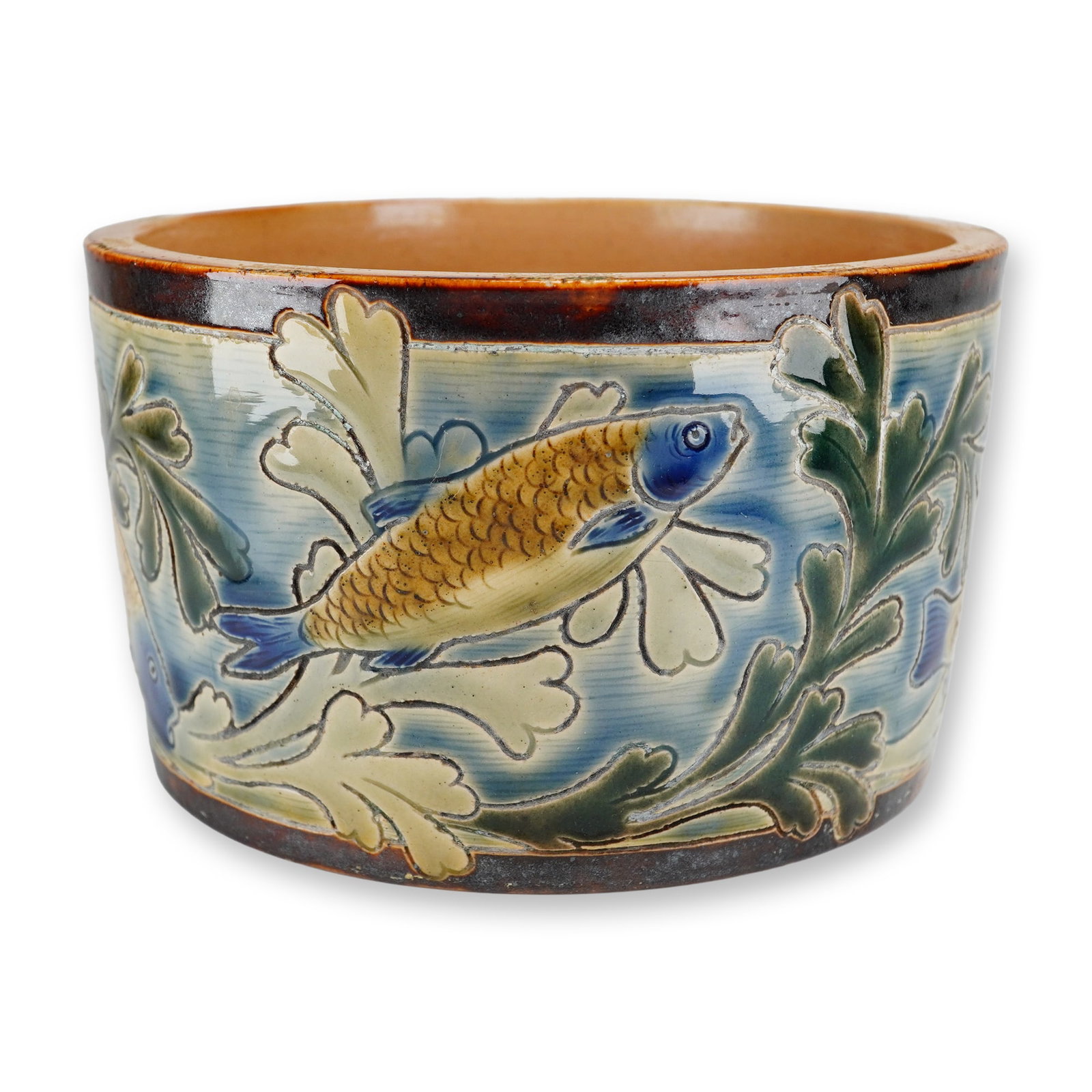 Doulton Lambeth by Mark V. Marshall and Harry Barnard Stoneware Underwater Motif Jardiniere: A cylindrical stoneware planter decorated in shades of blue, green, and brown, depicting an aquatic scene of fish swimming through seaweed with finely incised outlines. The underside bears the Doulton
