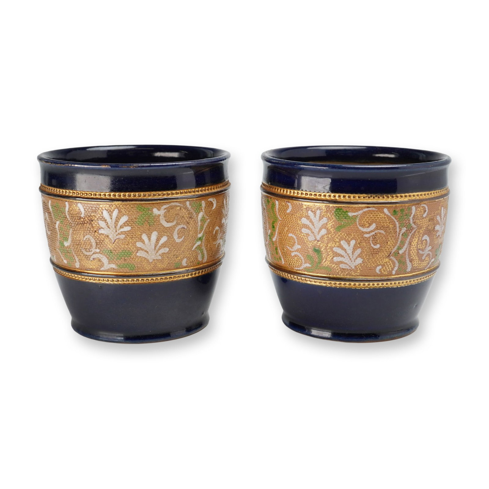 Pair of Doulton Slaters Patent Stoneware Cobalt and Gilt Vases: Each small, tapered cylindrical form features a deep cobalt blue glazed rim and base, centering a wide textured gilt band decorated with hand-painted floral and foliate designs in white and green enam