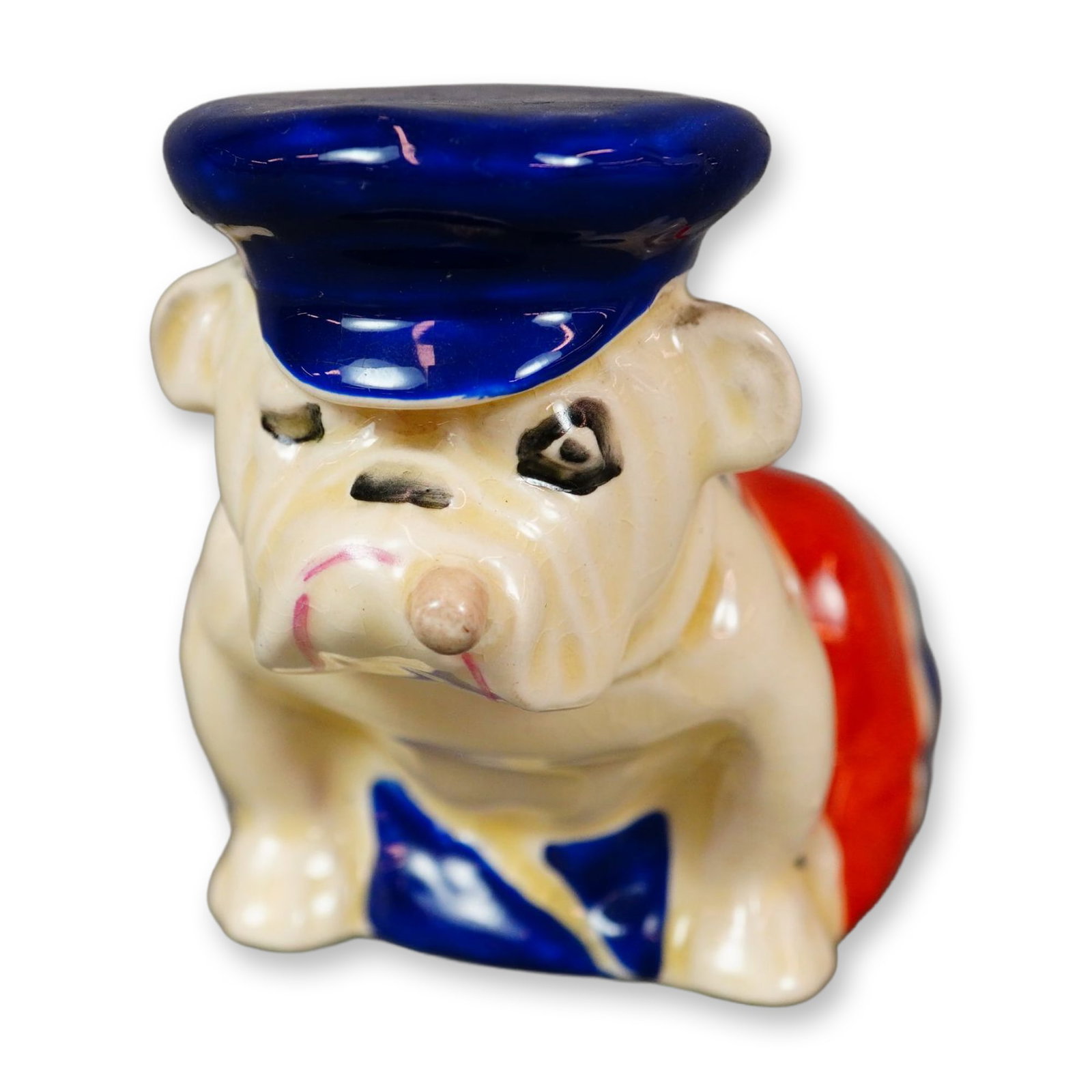 Royal Doulton Porcelain Small Figurine, Bulldog Draped in Union Jack with Trinity Cap D6183: The bulldog has long symbolized British strength, loyalty, and perseverance. Popularized during World War I as an emblem of national resolve, the breed remains closely associated with Great Britain. T