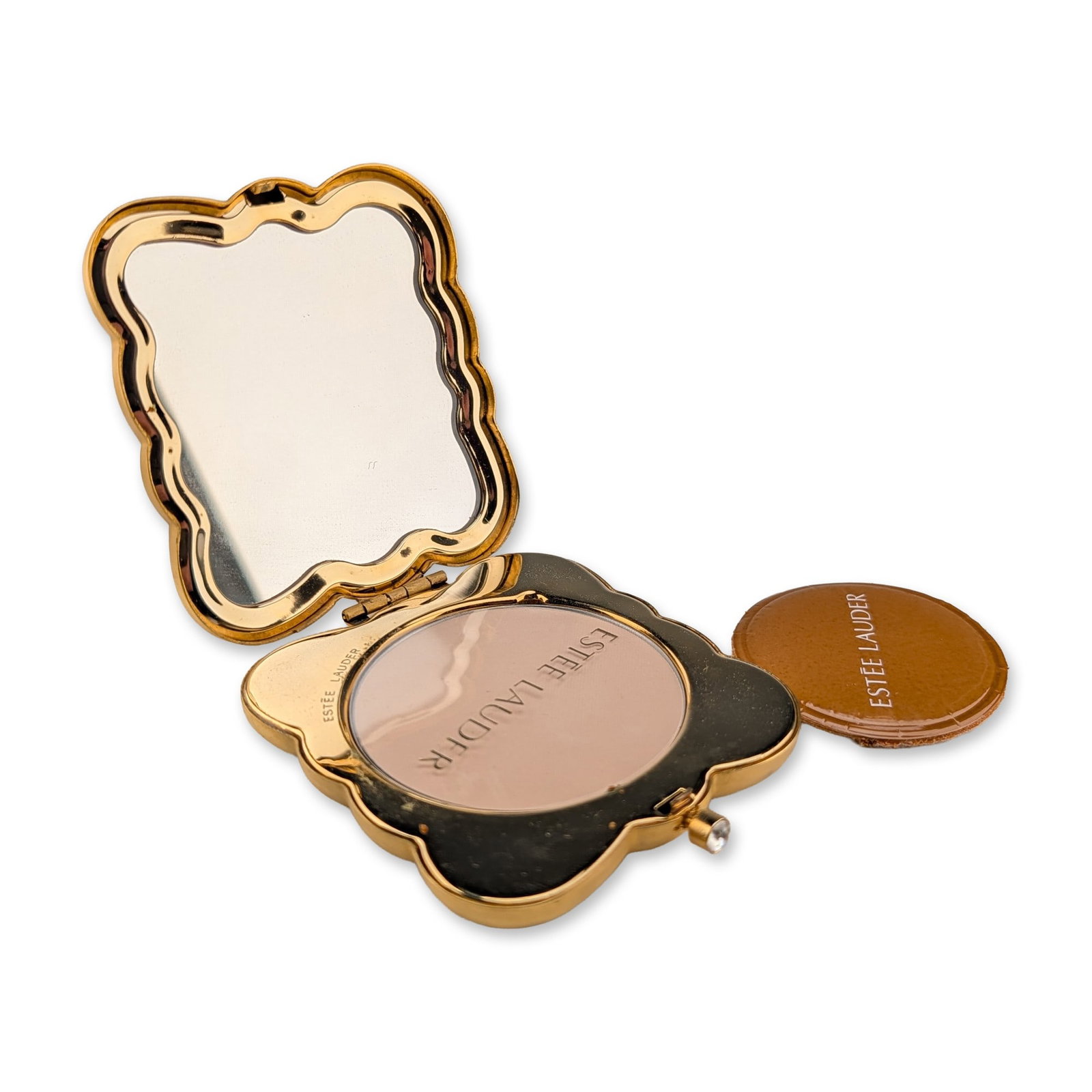 Estee Lauder Golden Sagittarius Gold-Tone Powder Compact: Estee Lauder collectible Golden Sagittarius powder compact featuring a sculpted gold-tone metal case in a scalloped square form. The lid is adorned with a raised bow and arrow motif accented with clea