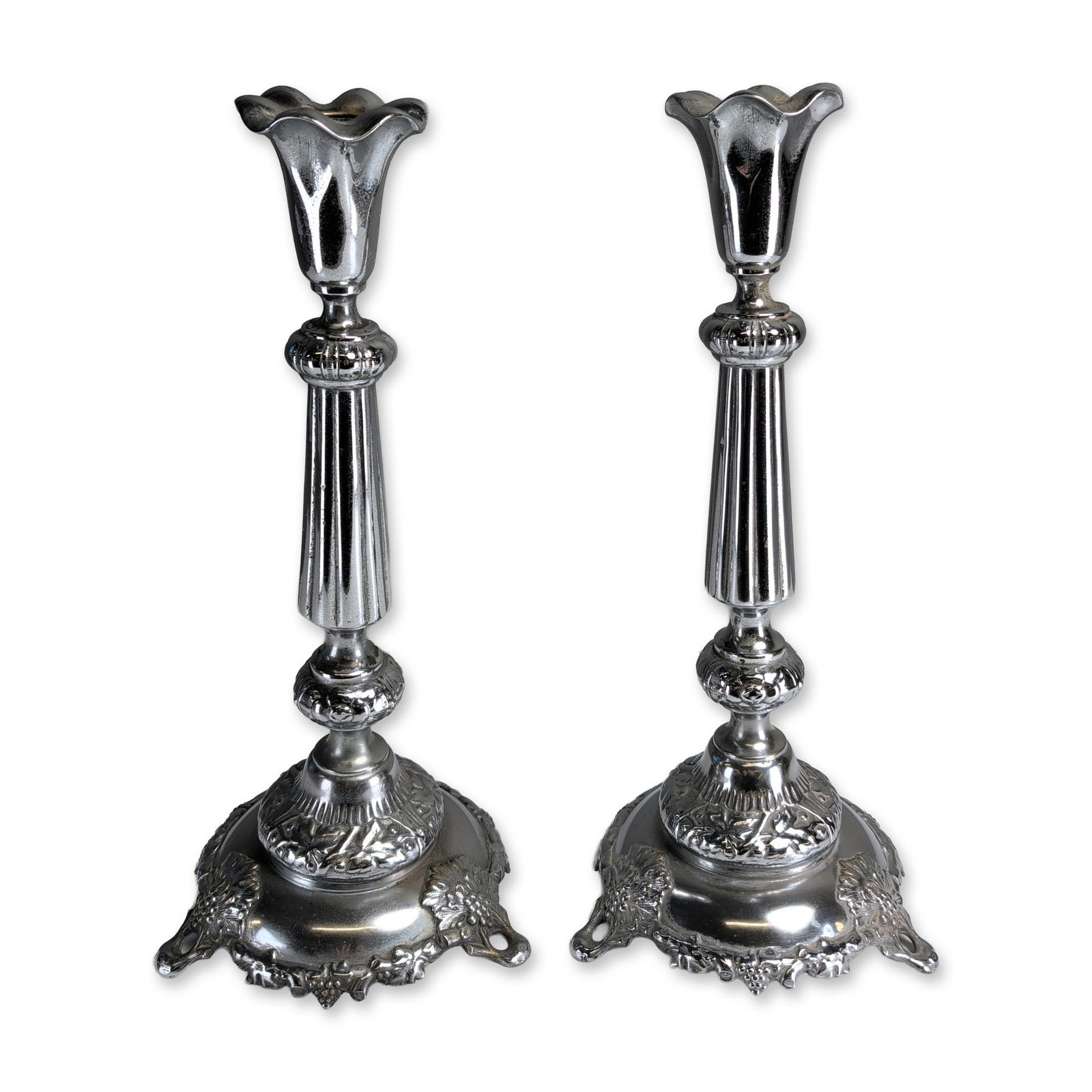 2pc Josef Fraget Company Poland Silver-Toned Sabbath Candlestick Holders: Pair of silver-toned Sabbath candlestick holders by Josef Fraget Company, Poland, featuring fluted central columns and circular bases. Decorative motifs include cast scrollwork, acanthus leaves, and f